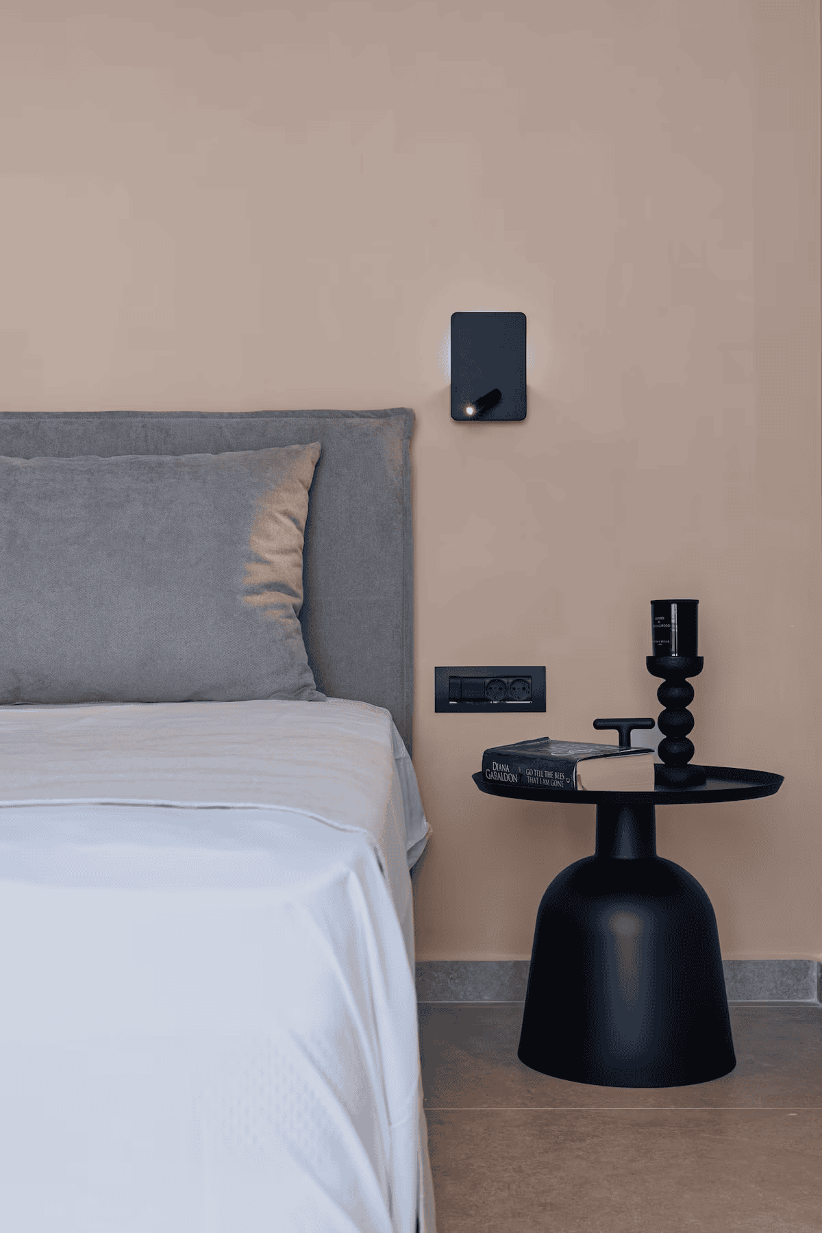 a black lamp next to a bed