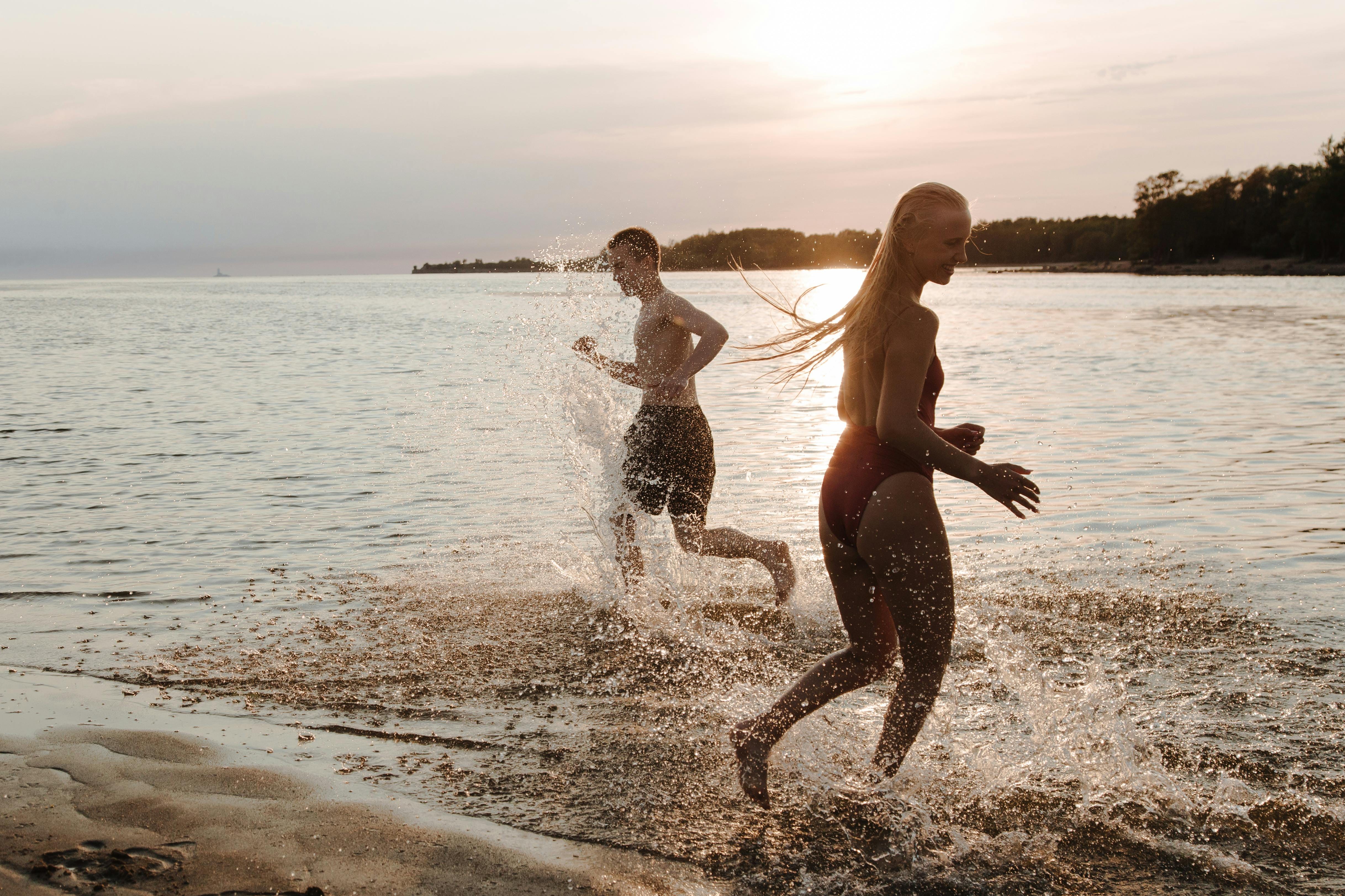 two boys running on a beach