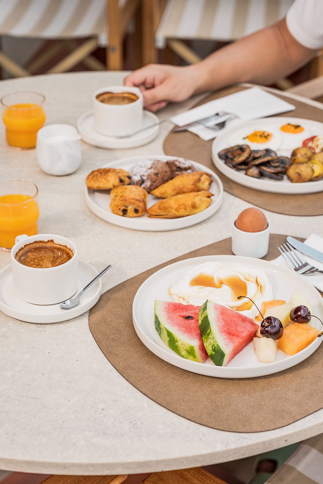 a table with plates of food and cups of coffee