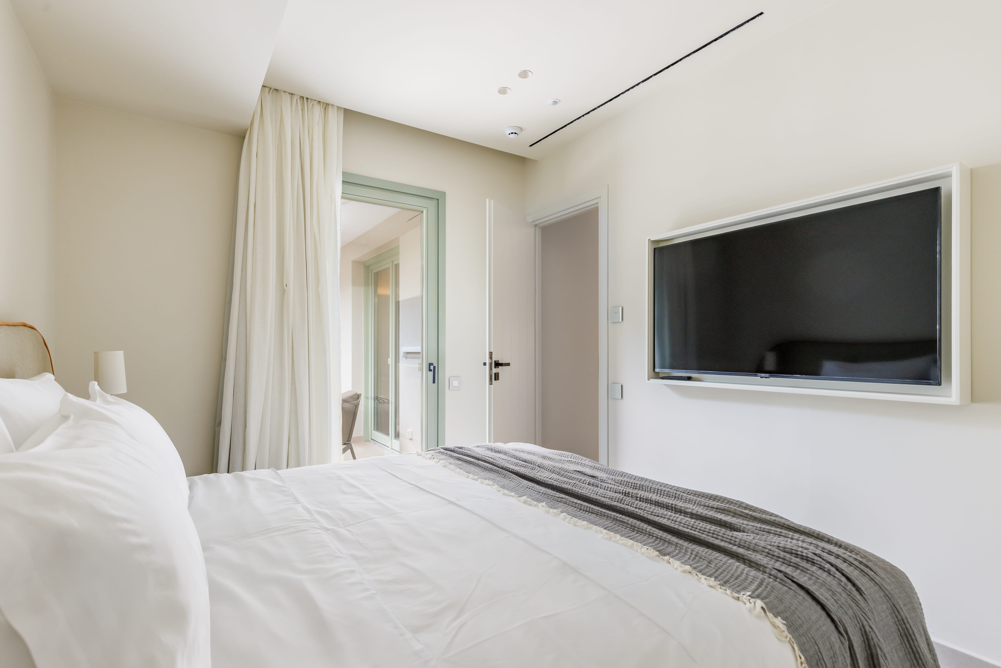 a bed with a tv on the wall