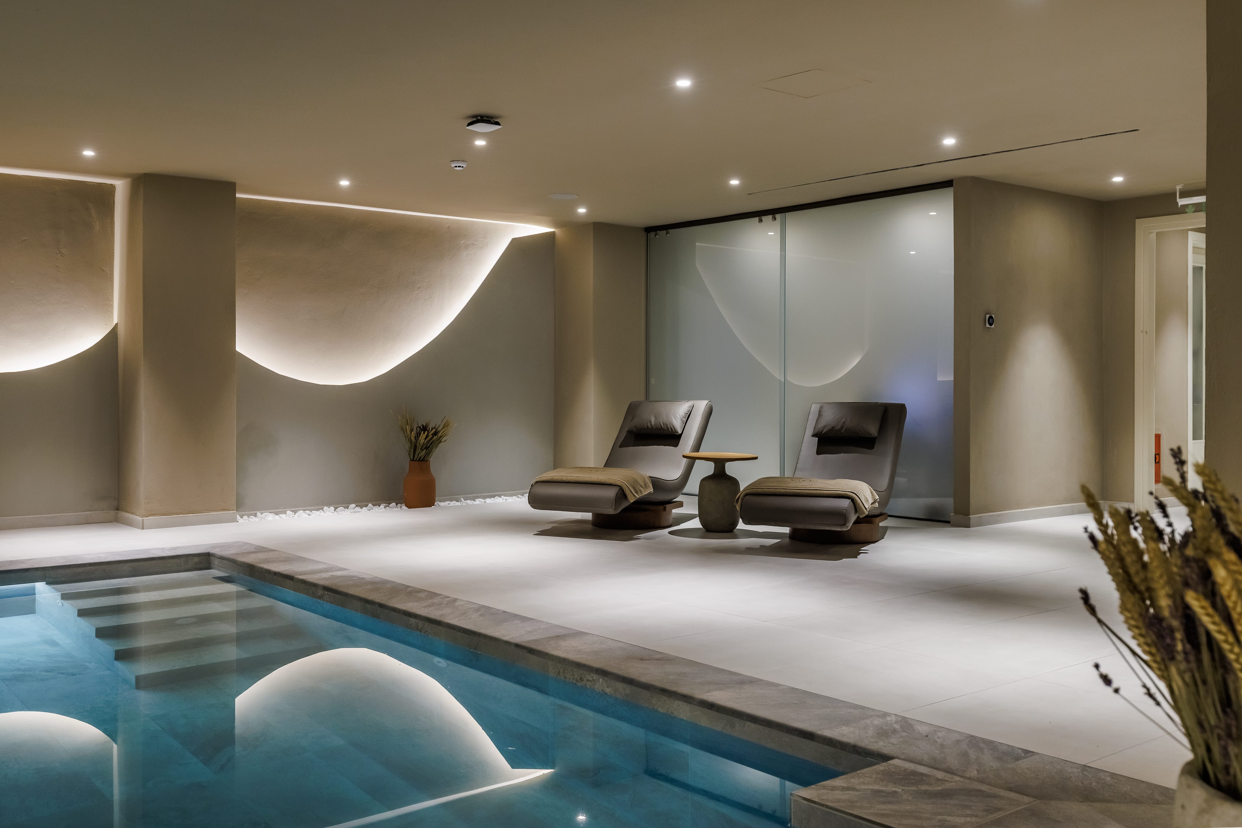 a swimming pool with a lounge chair and a plant