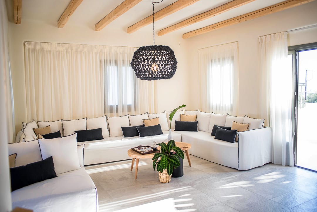a living room with white couches and a chandelier