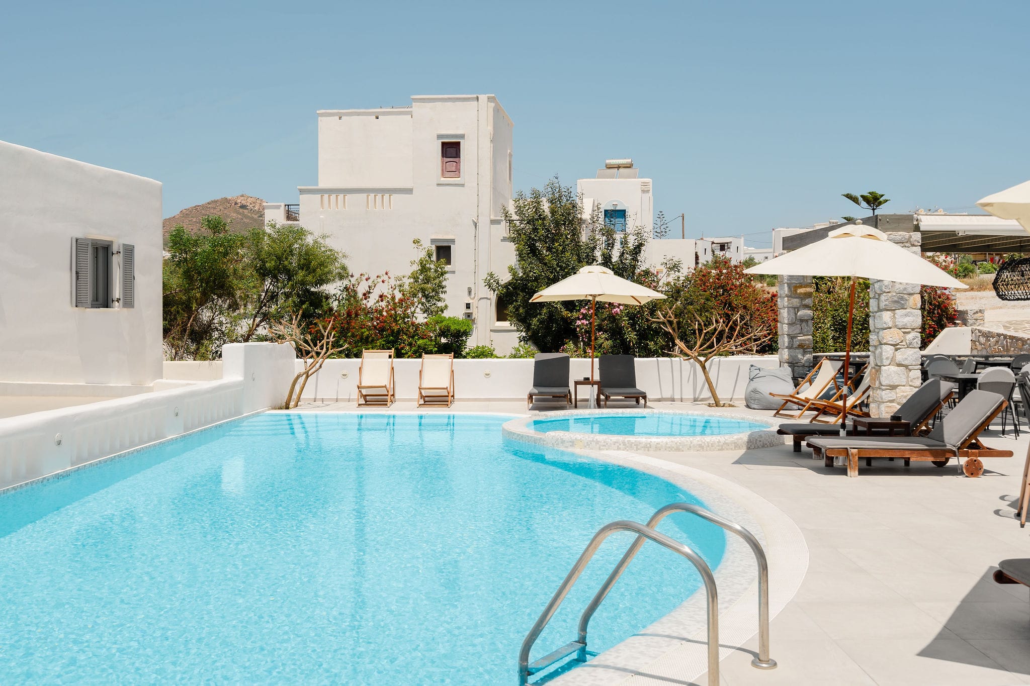 a pool with chairs and umbrellas by it