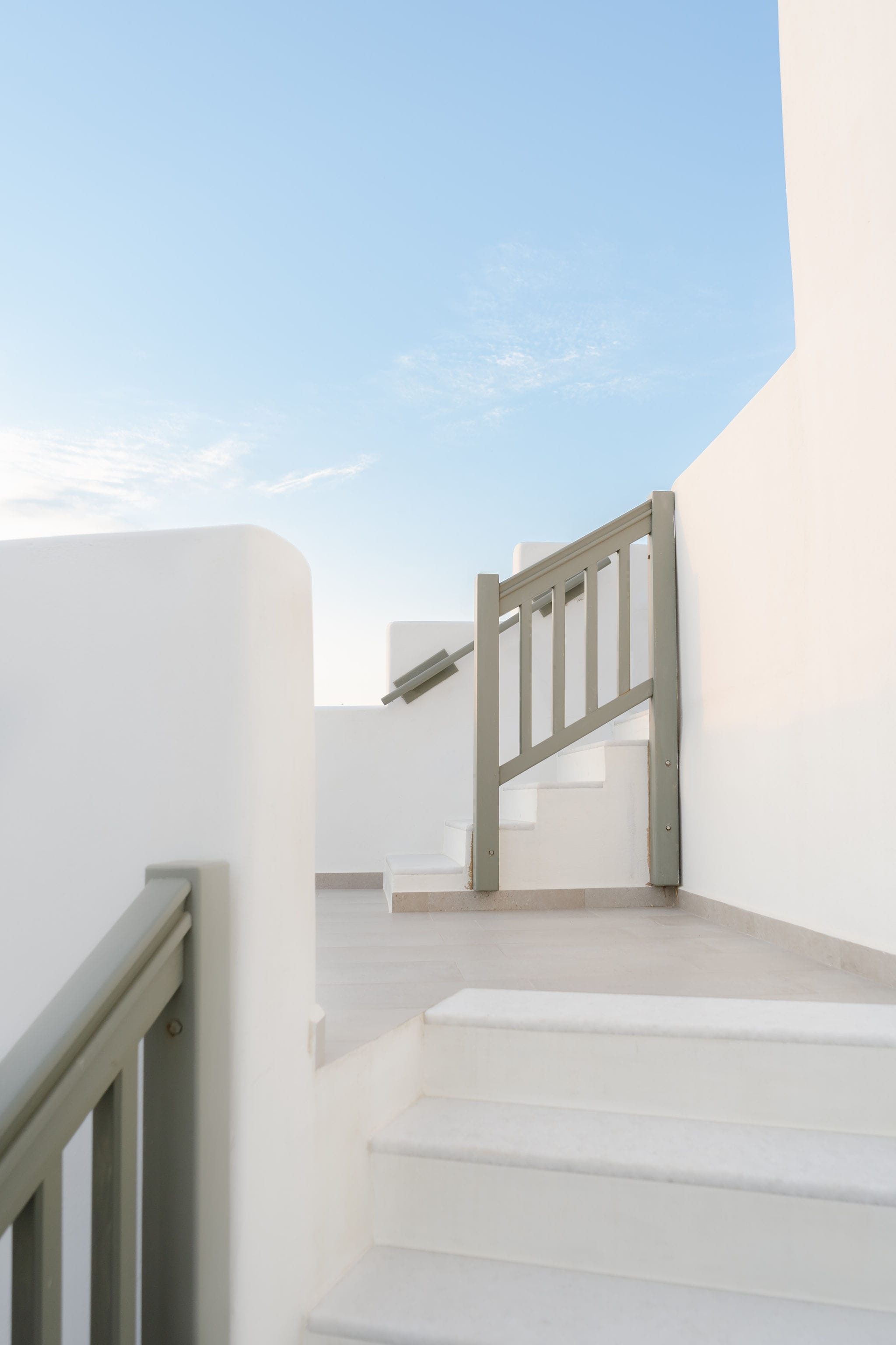 a white staircase leading up to a blue sky