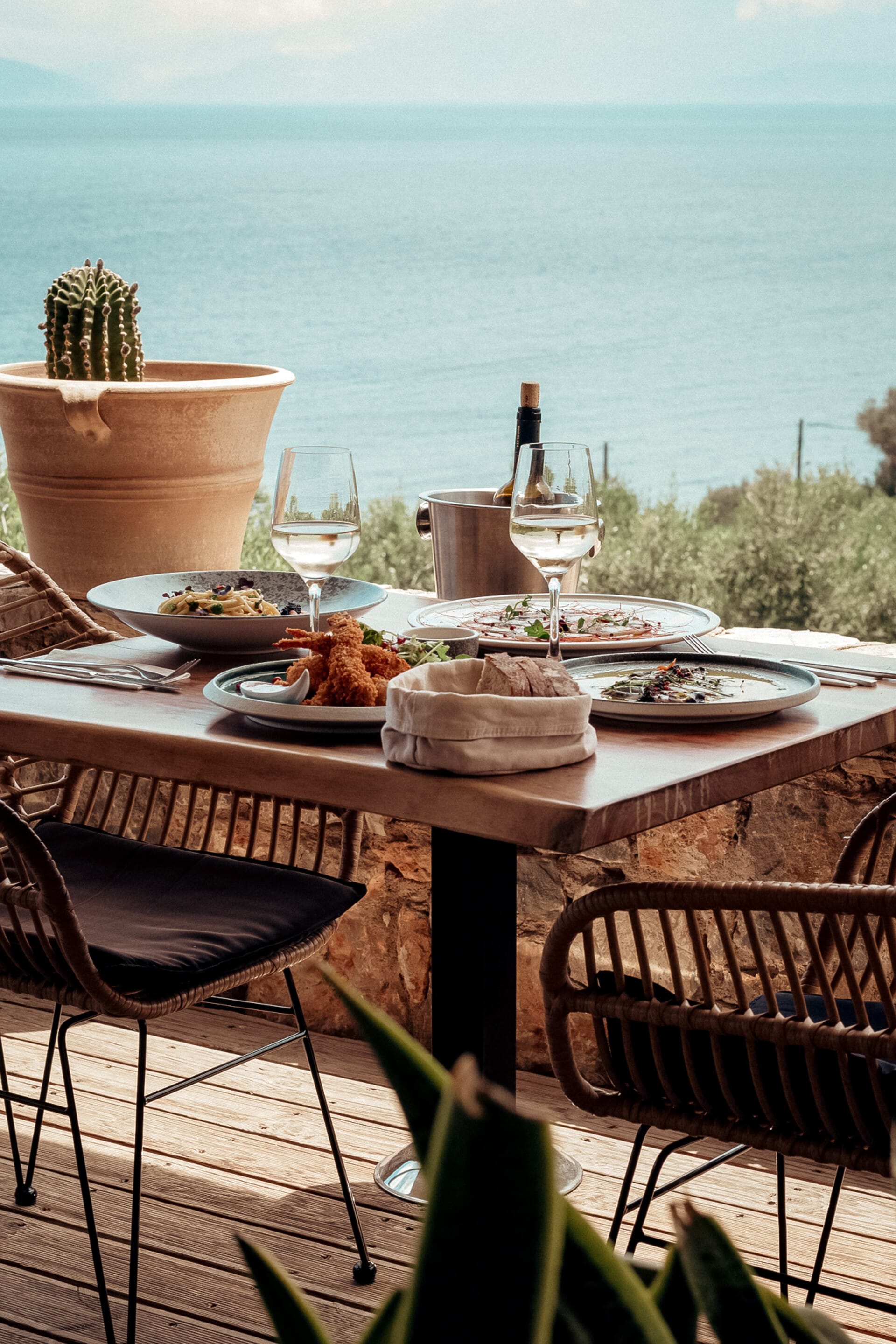 a table with plates and glasses on it by a body of water