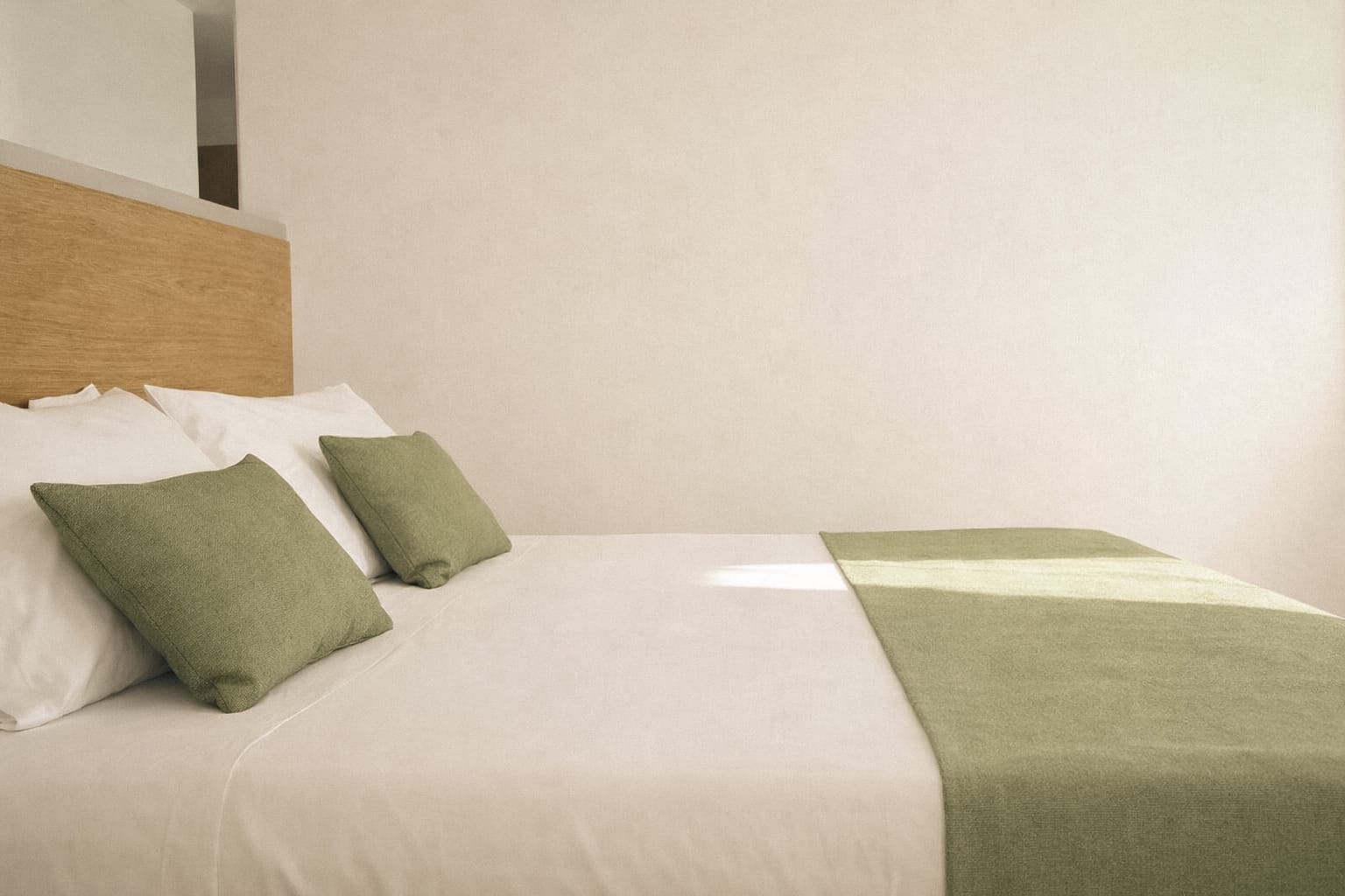 a bed with green pillows