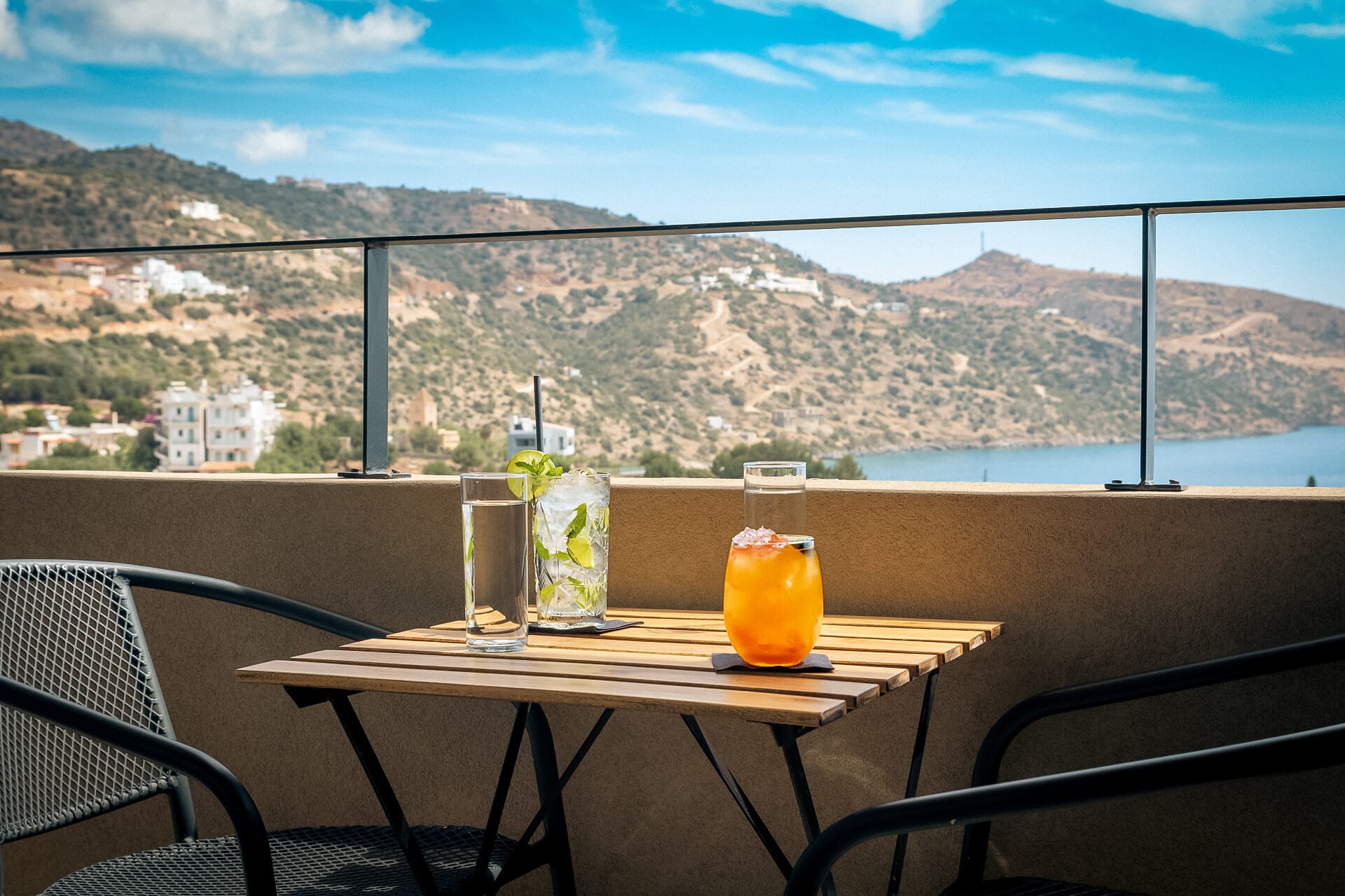 a table with a glass of orange juice and a city in the background