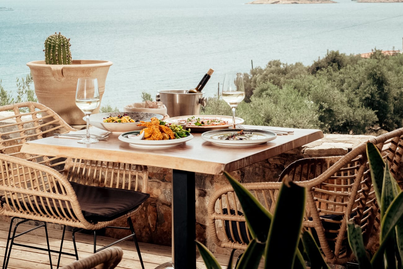 a table with plates of food on it by a body of water