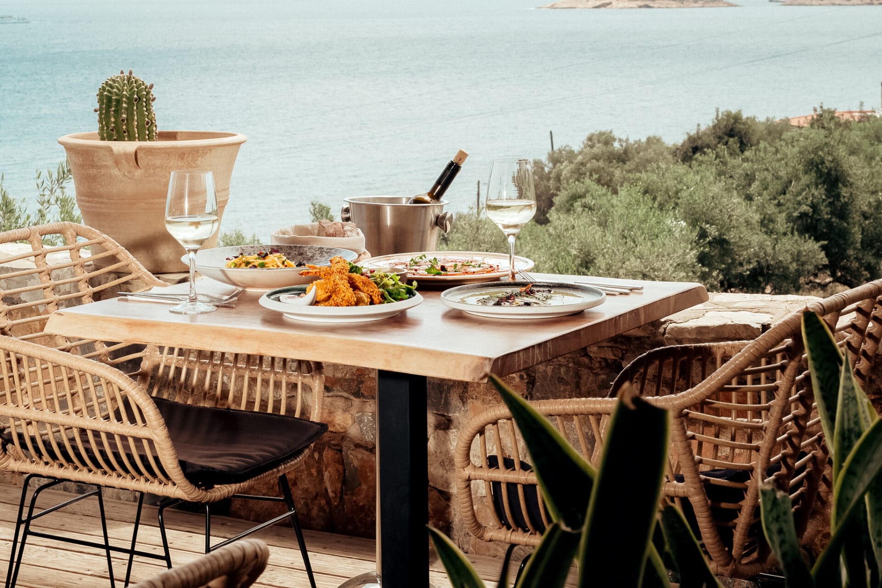 a table with plates of food on it by a body of water
