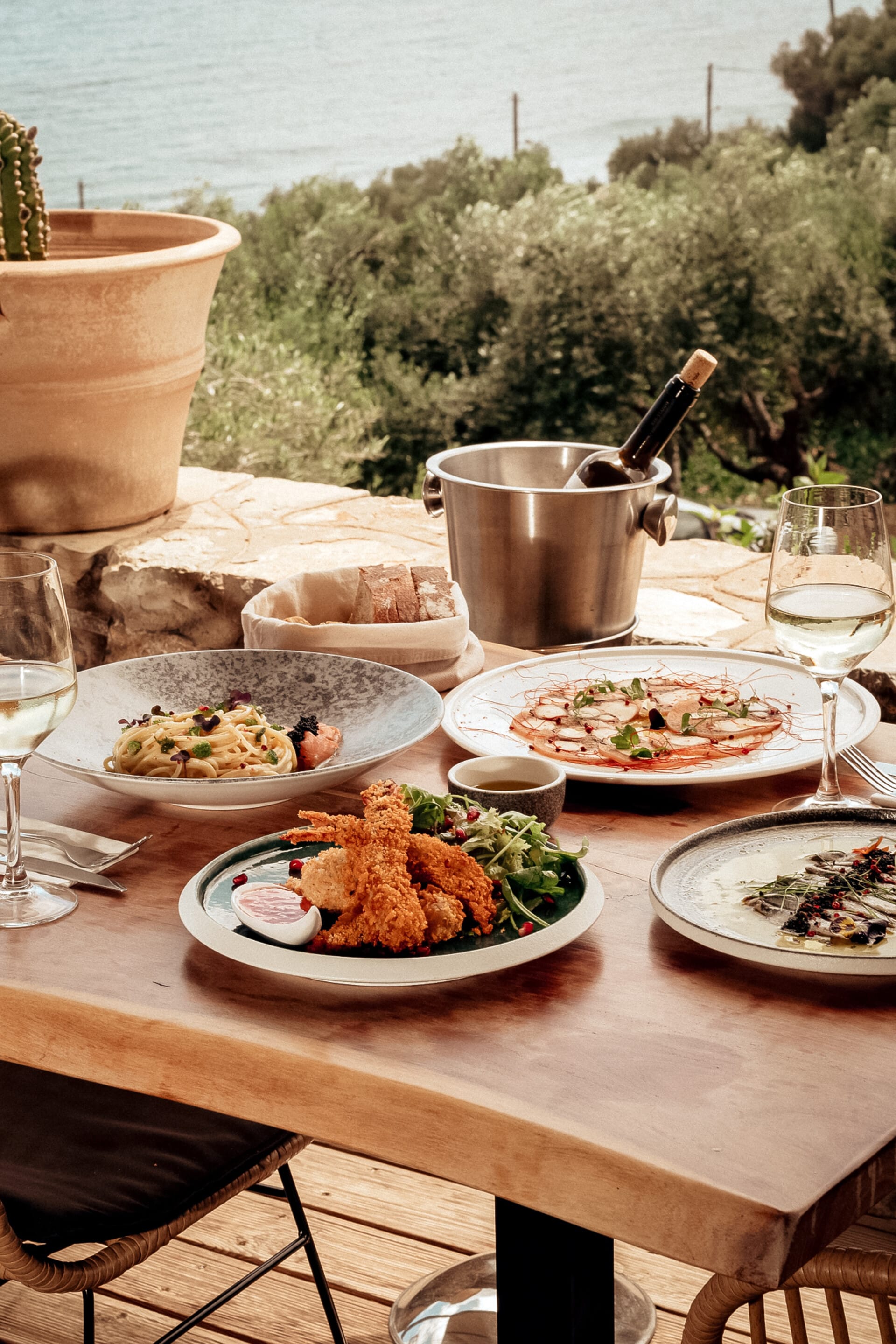 a table with plates of food and glasses of wine