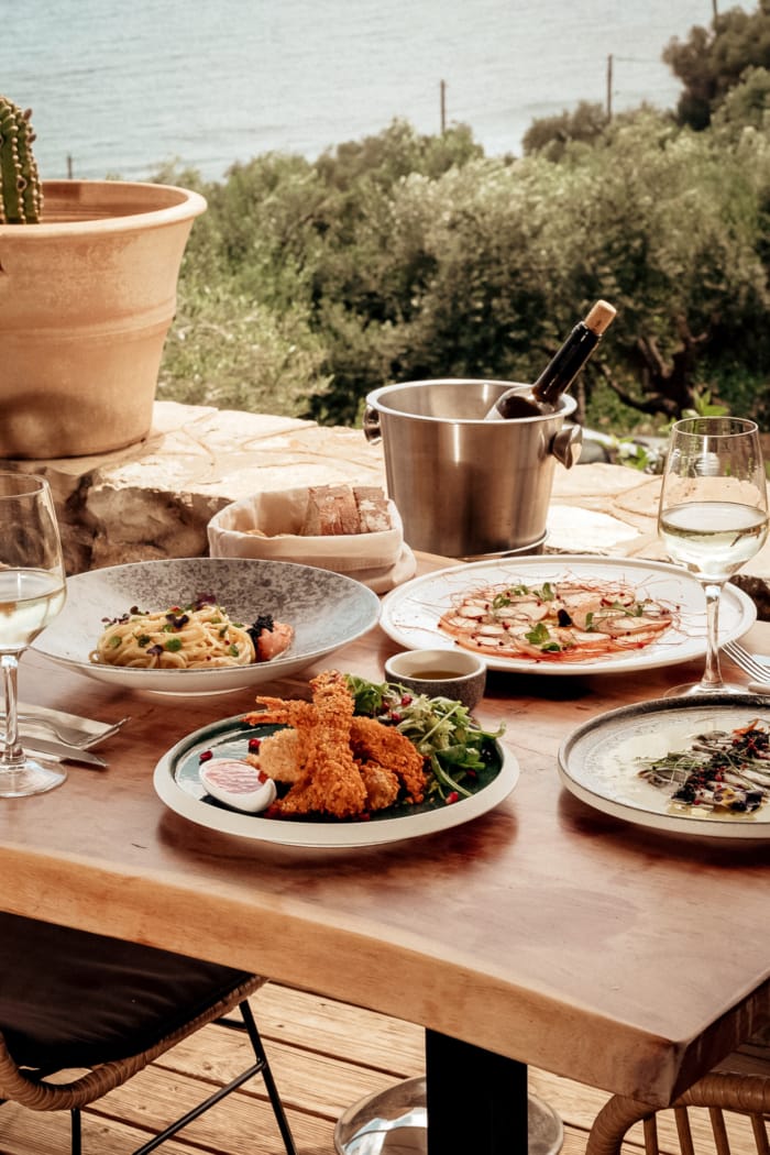 a table with plates of food and glasses of wine