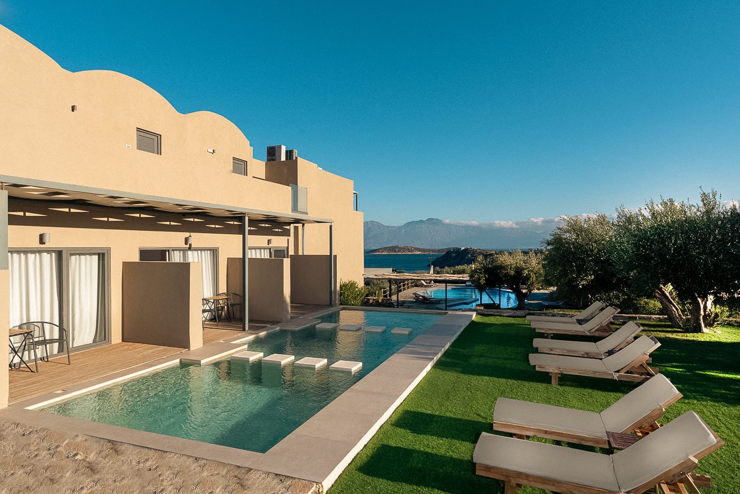 a pool and lounge chairs in a backyard