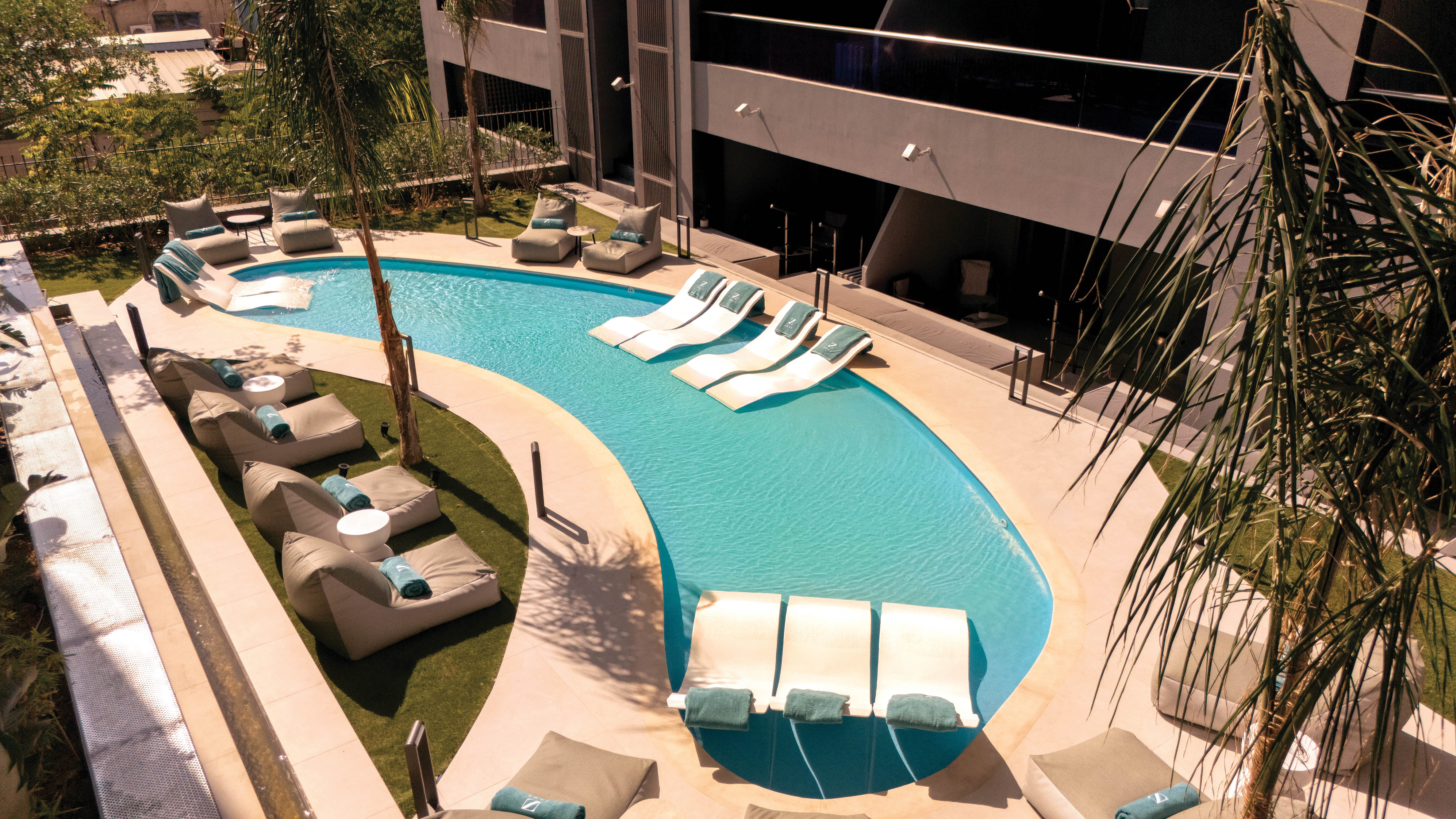 a pool with lounge chairs and a lounge chair