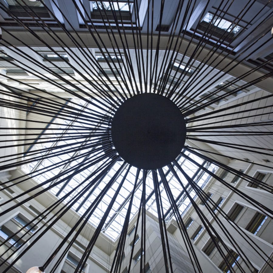 a large glass ceiling with a round black object in the center