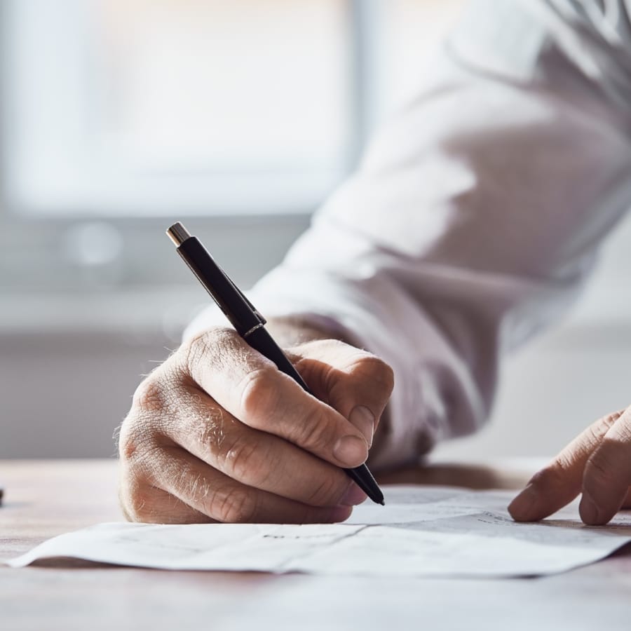 a person writing on a piece of paper