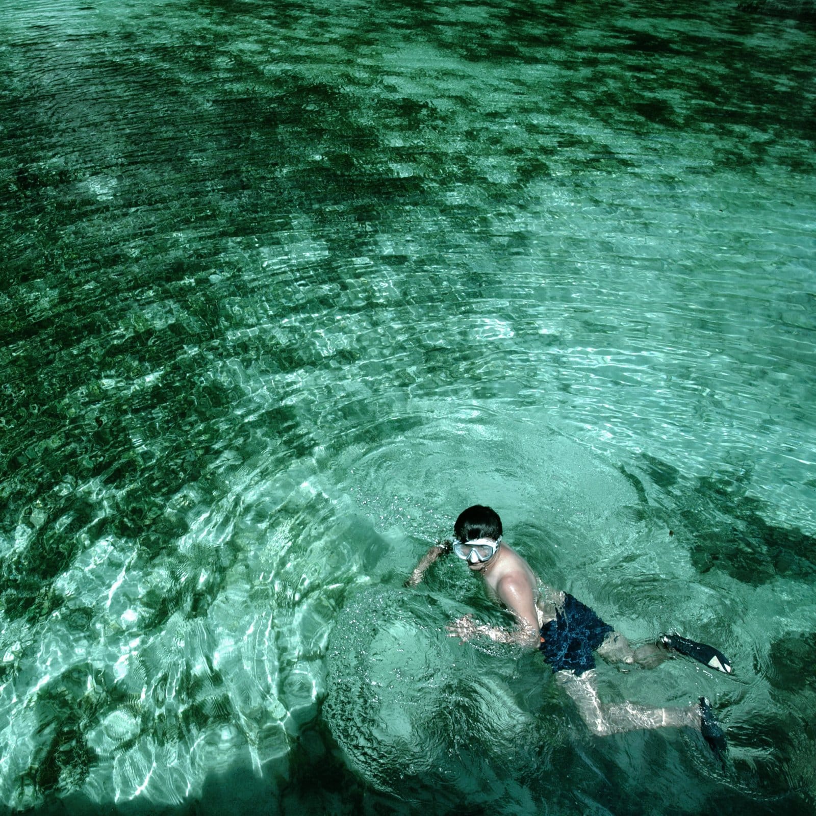 a man lying on a rock in a river