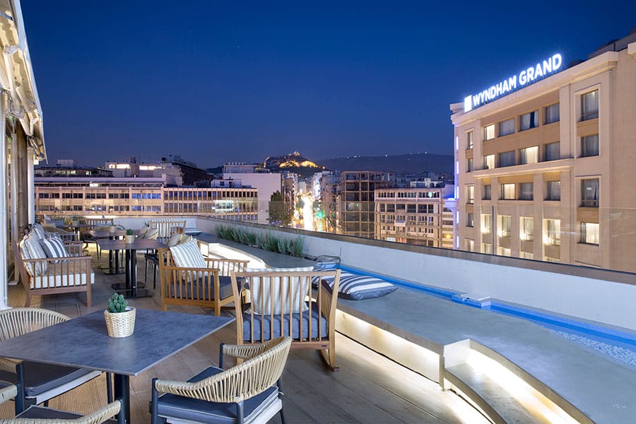 a pool and chairs by a building