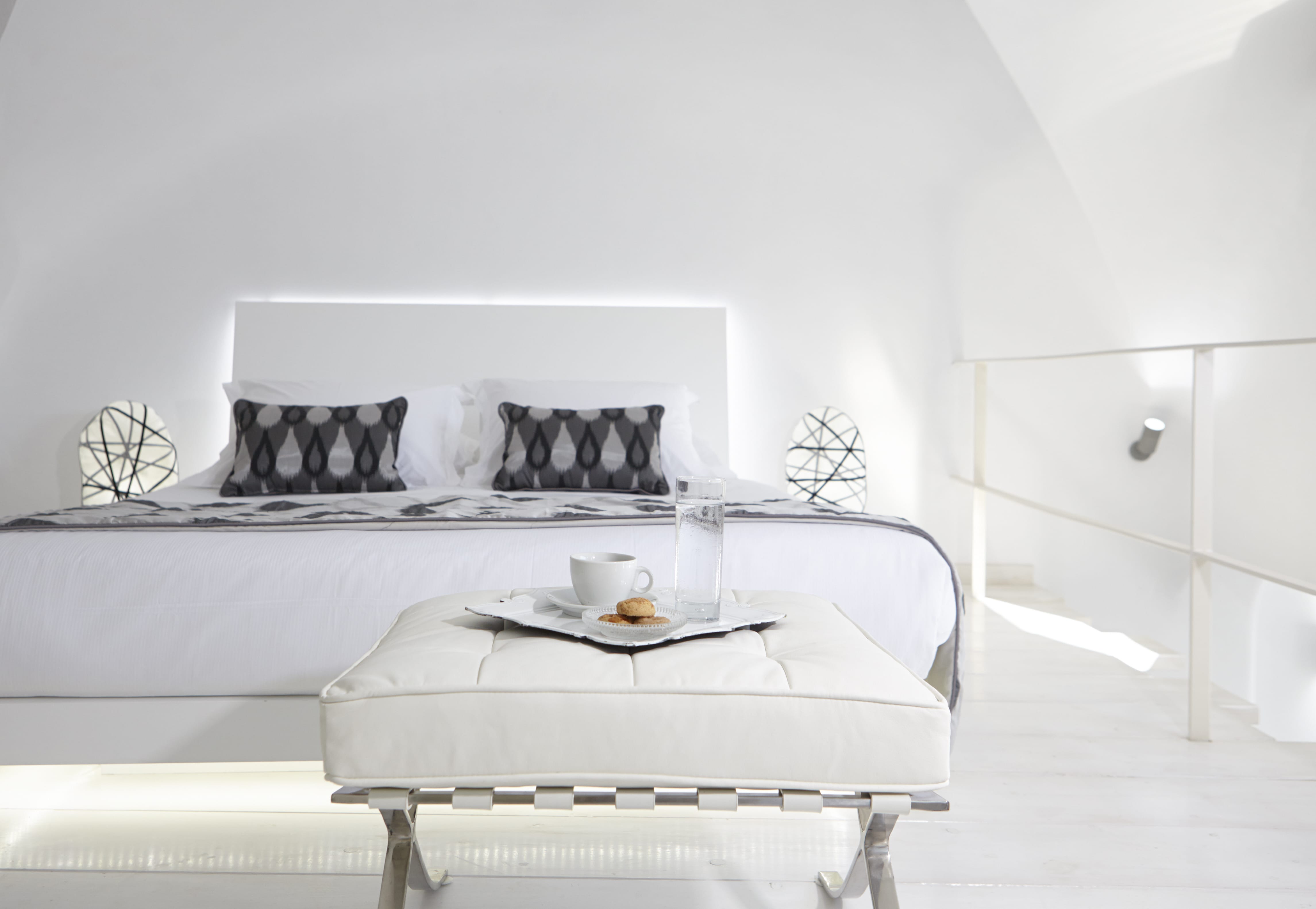 a white bed with a white bed frame and a white bed