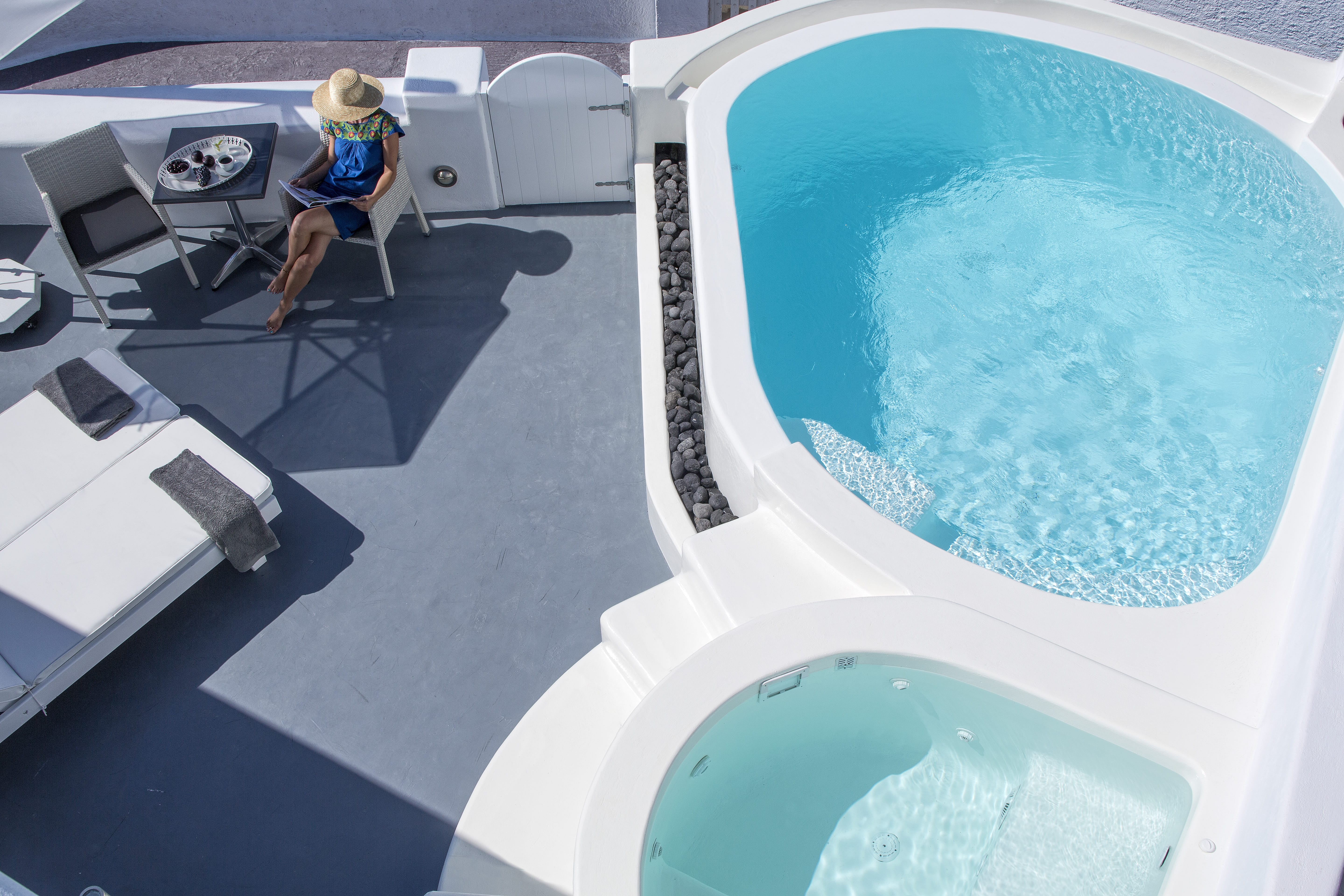 a person sitting in a chair next to a pool