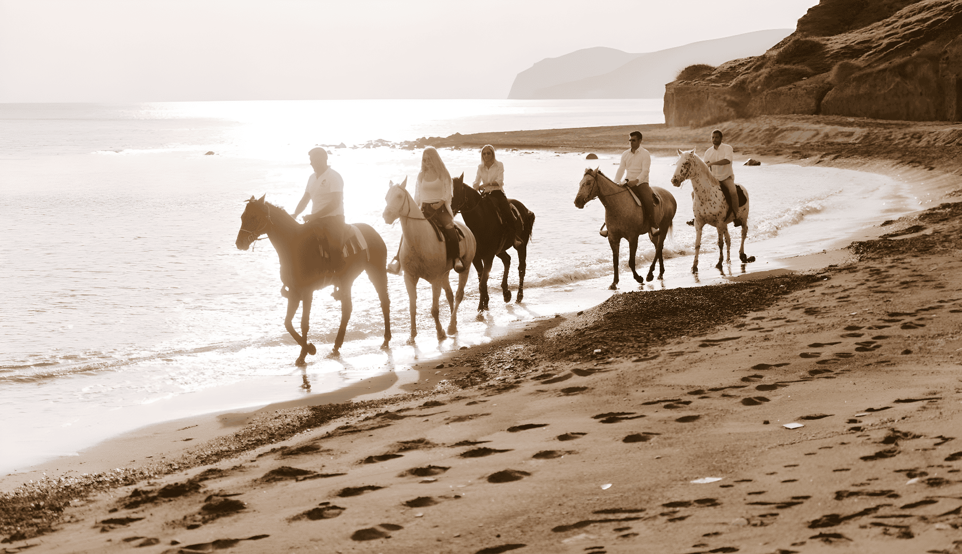 people riding horses on a beach