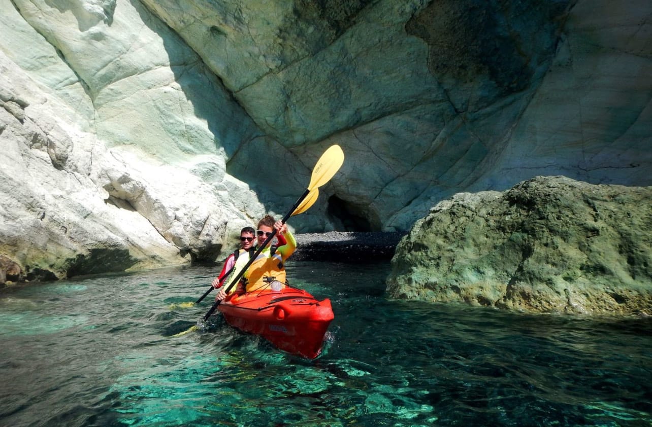 a person in a kayak in a river between large rocks