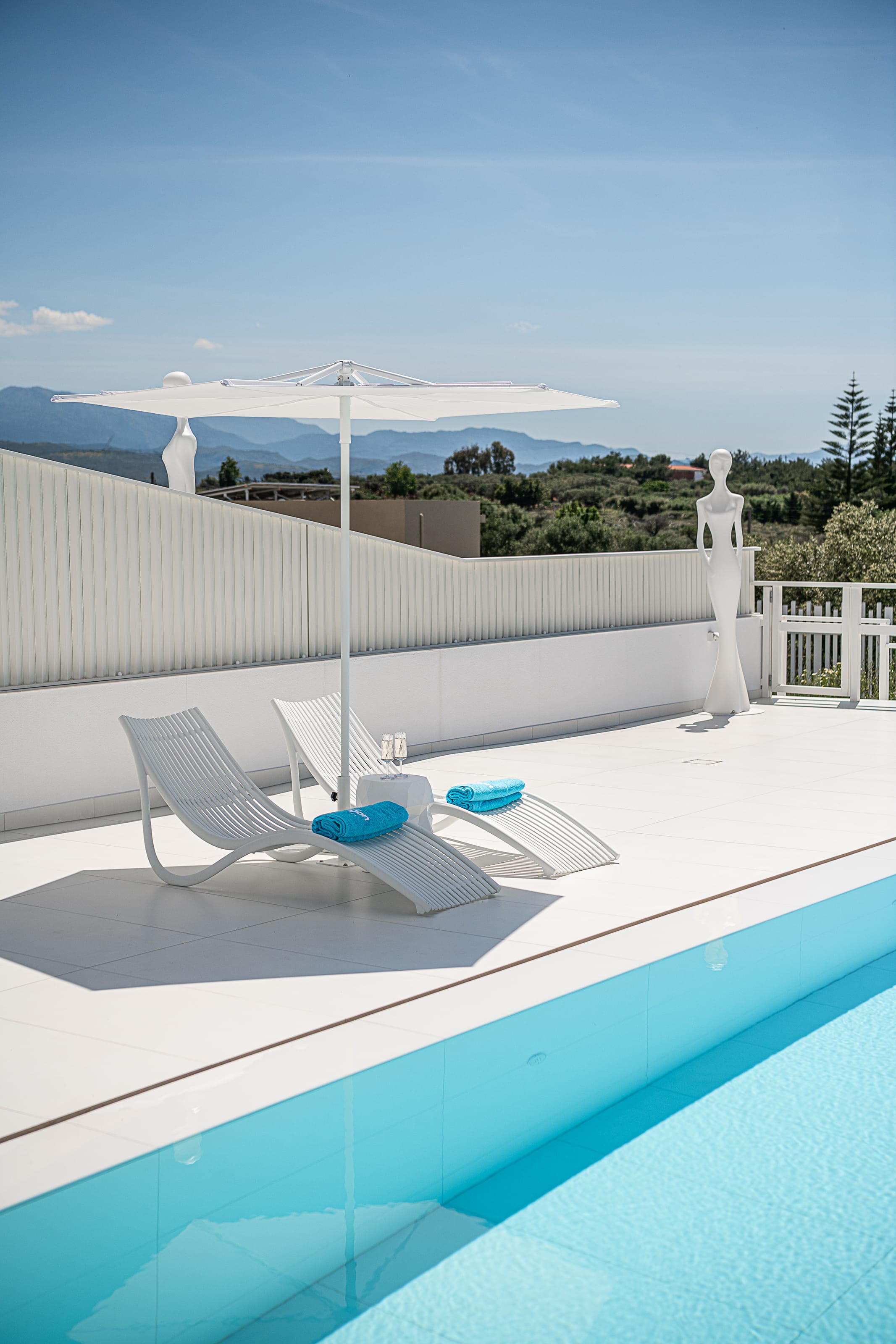 a pool with a white deck chair and umbrella