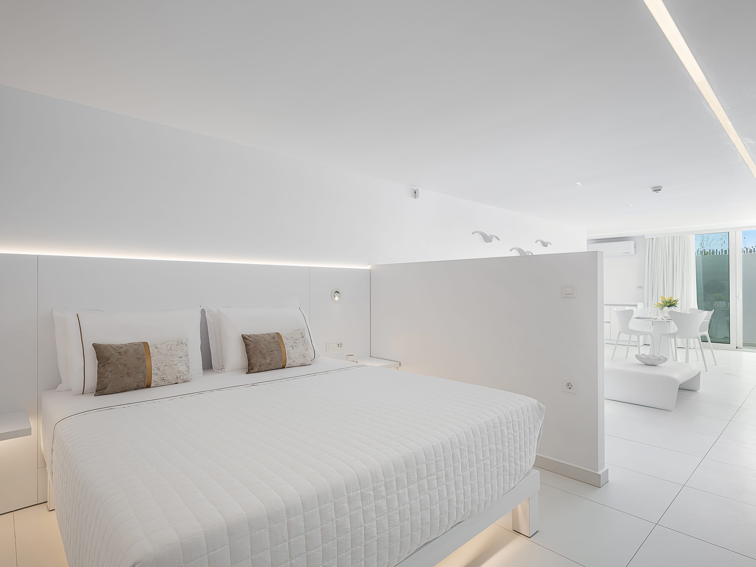 a white bedroom with a bed and a bathtub