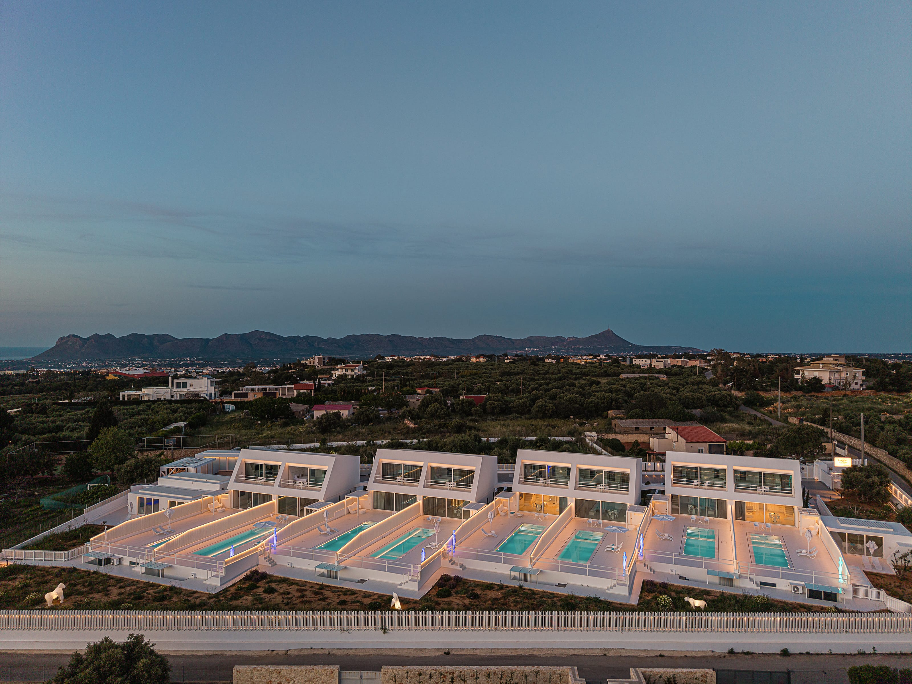 a group of white buildings with a pool in the middle