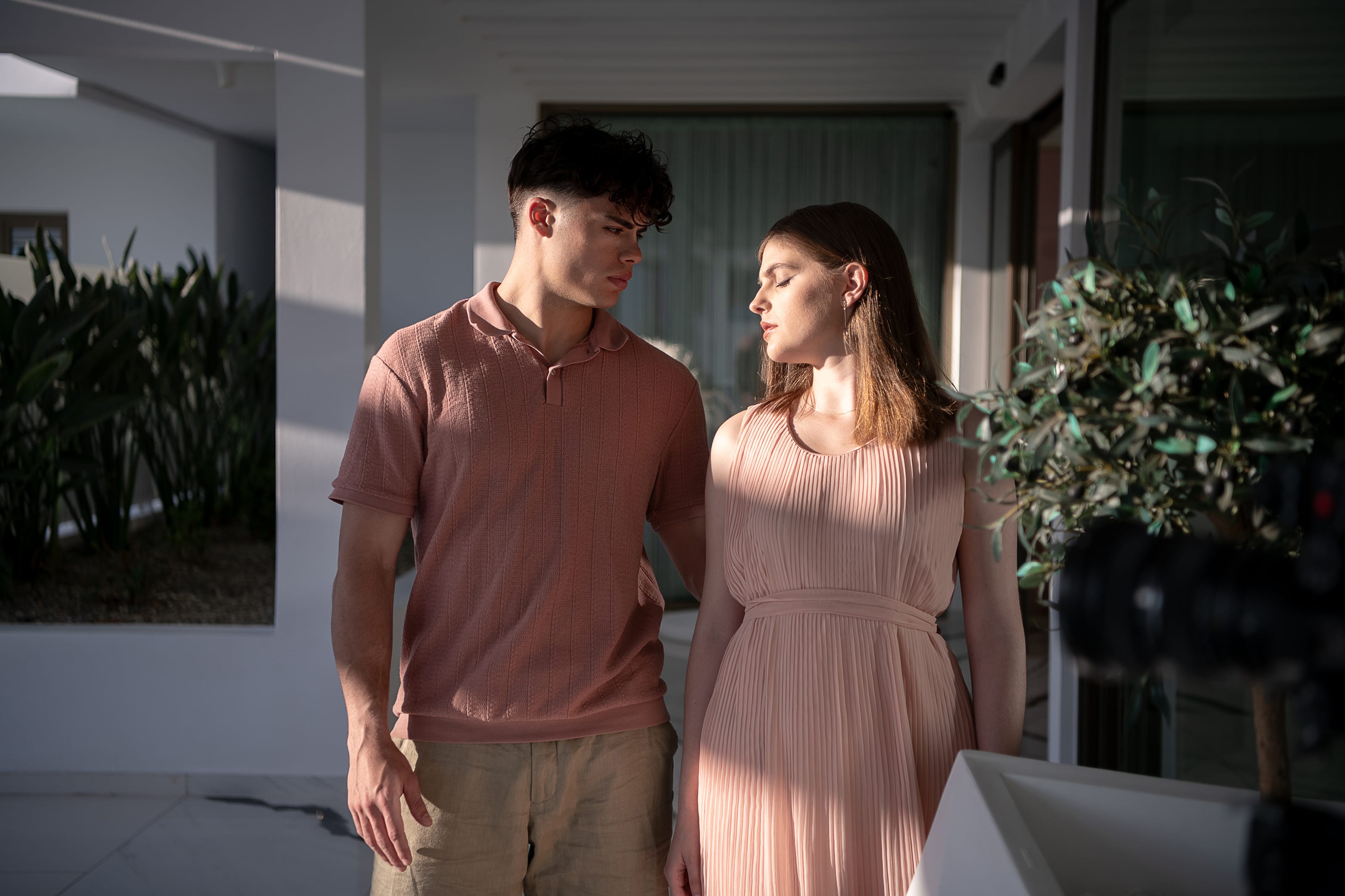a man and woman standing next to each other and looking at each other