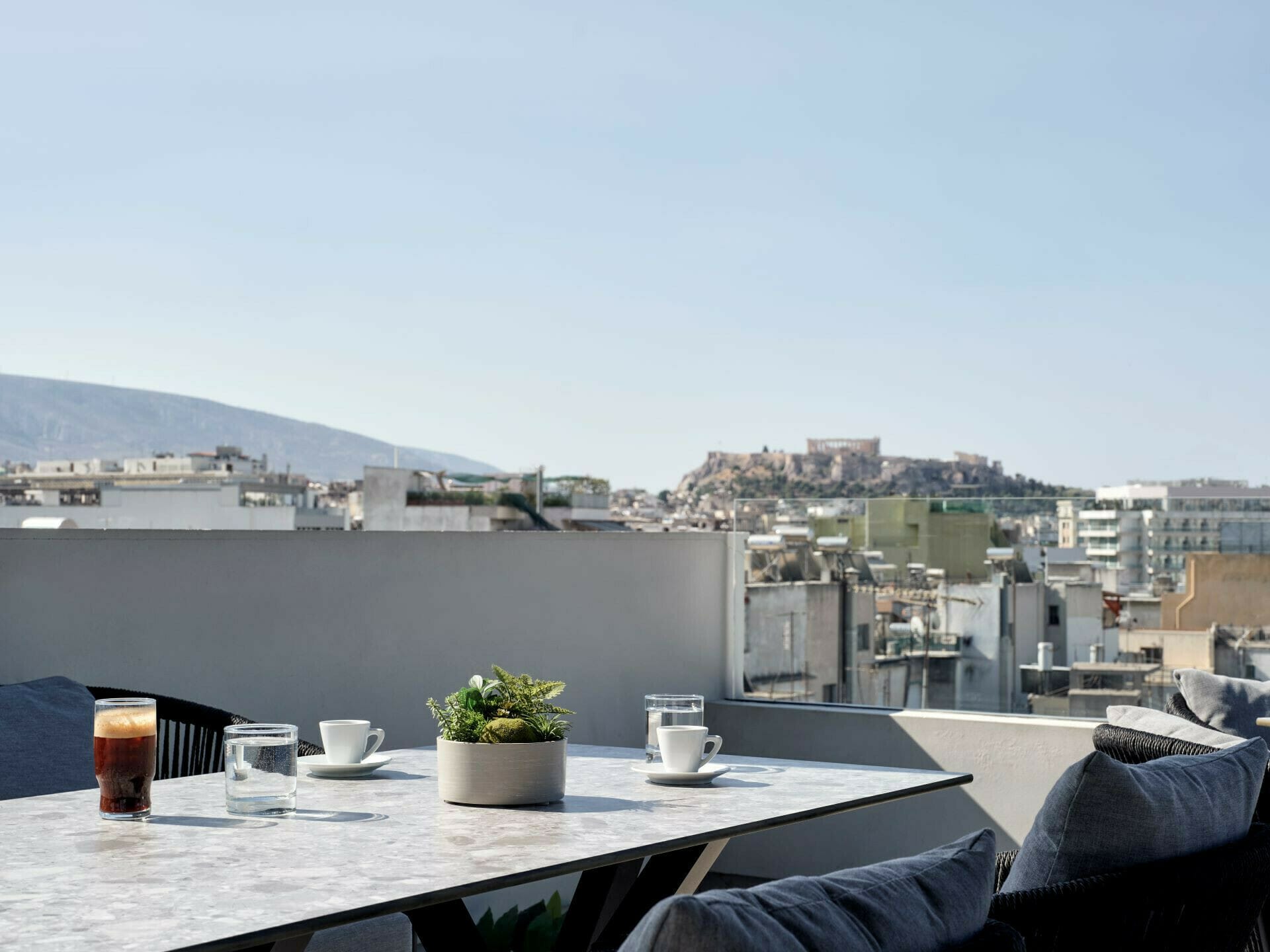 a table with a plant on it with a view of a city and water in the background