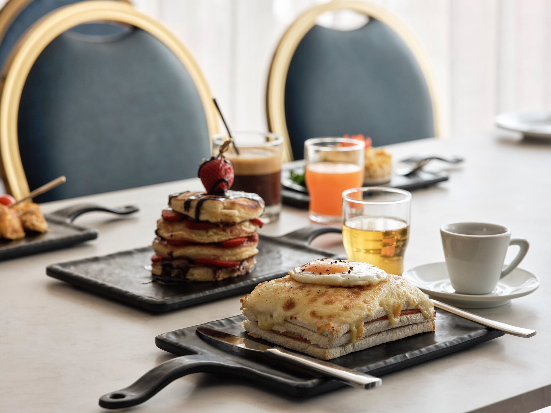 a table with a plate of desserts and glasses of juice