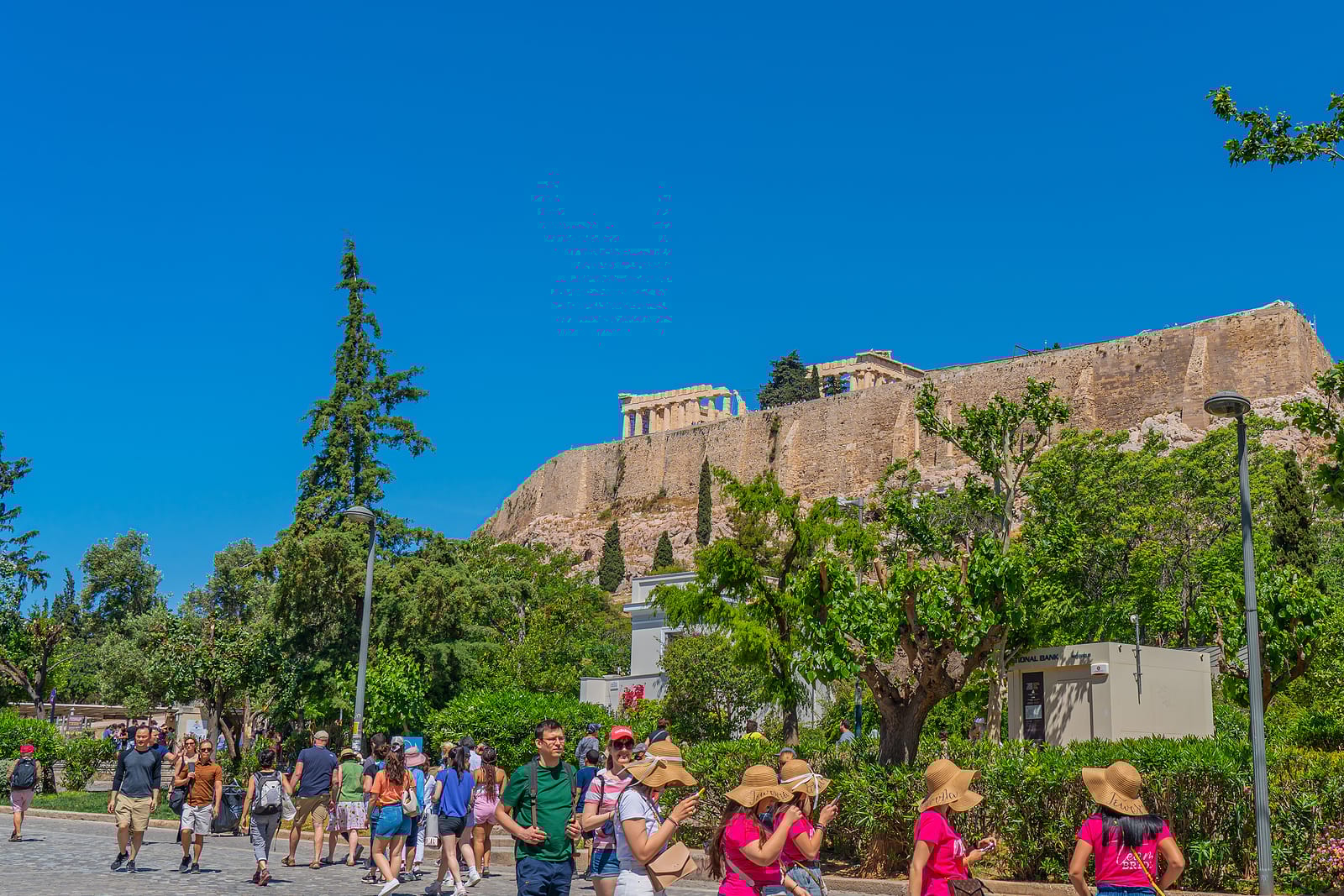 a group of people walking around a large rock structure
