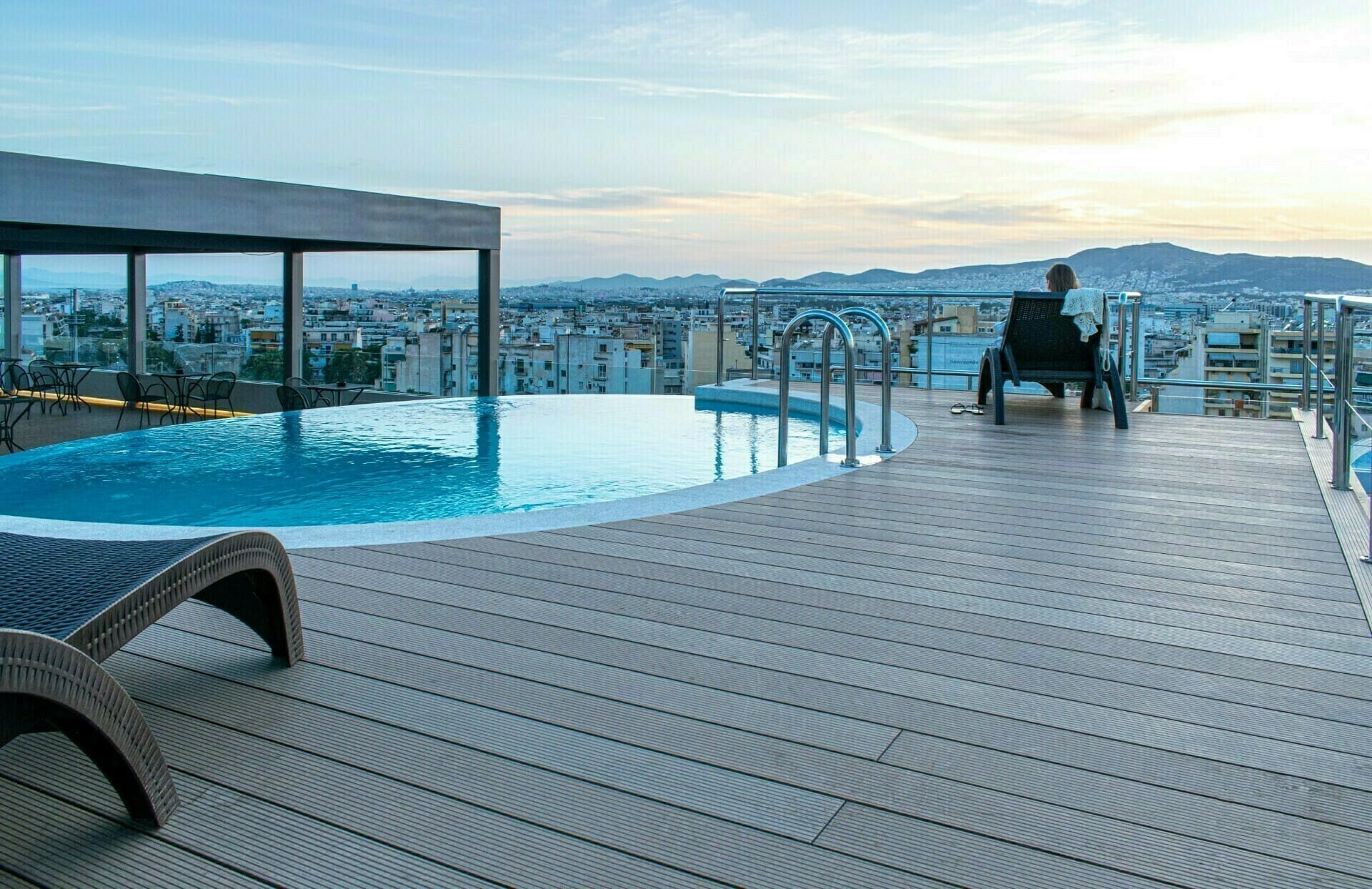 a person sitting on a chair by a pool