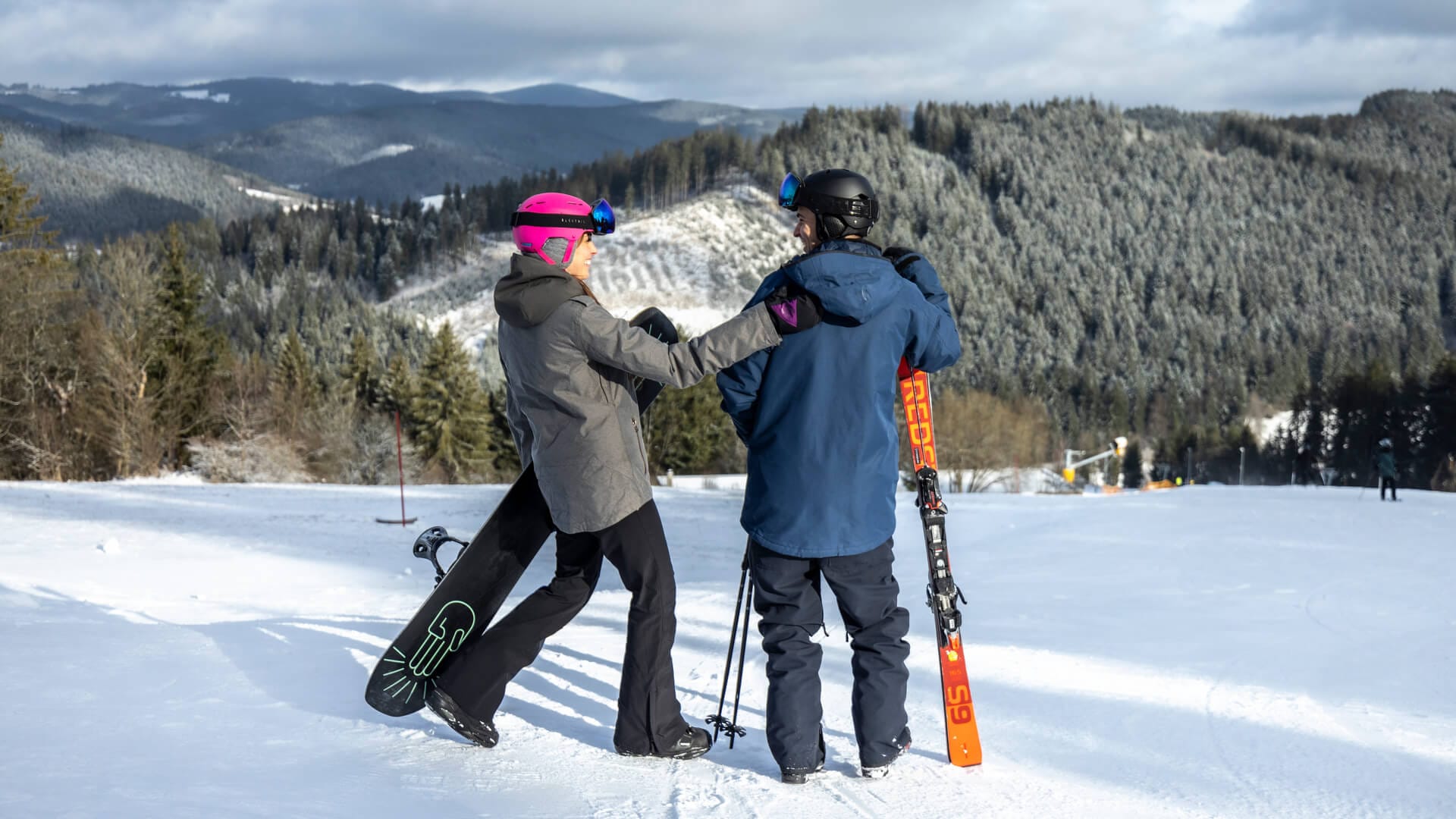 a couple of people stand on snow skis