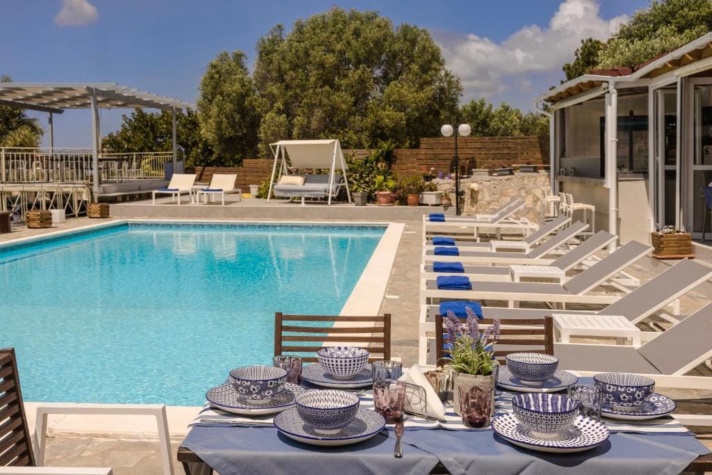 a table with plates and glasses on it by a pool