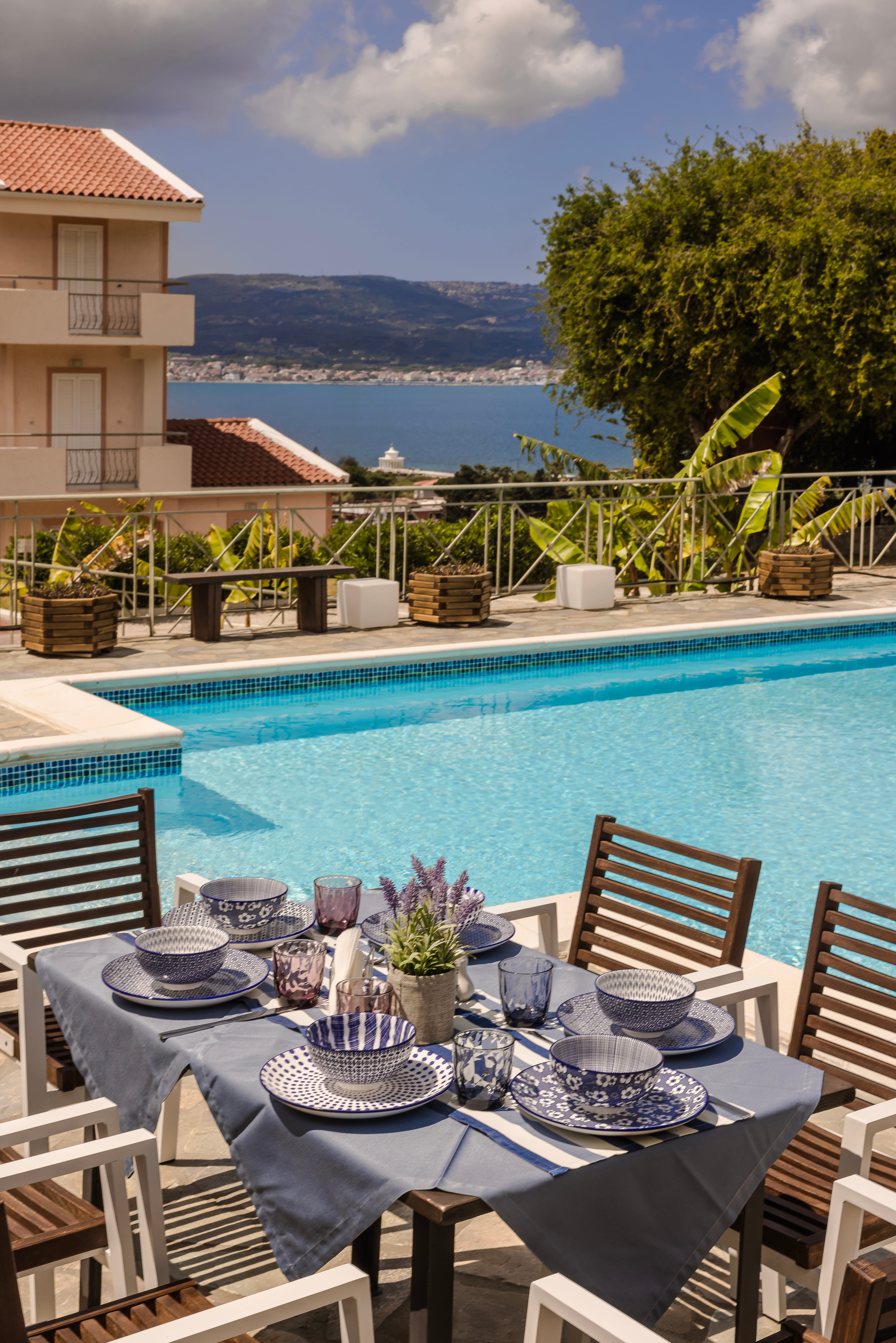 a table with plates and glasses on it by a pool