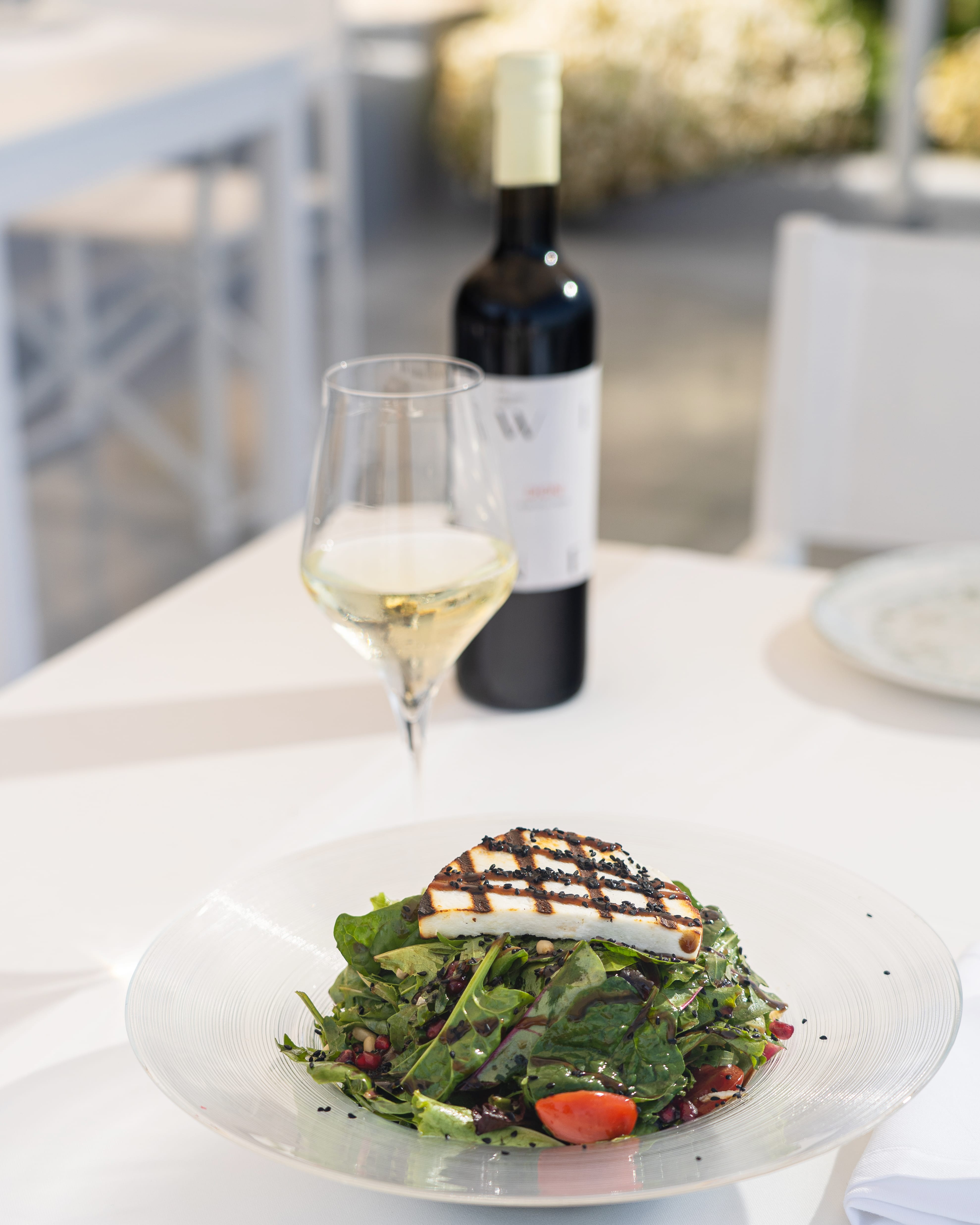 a plate of food and a bottle of wine on a table