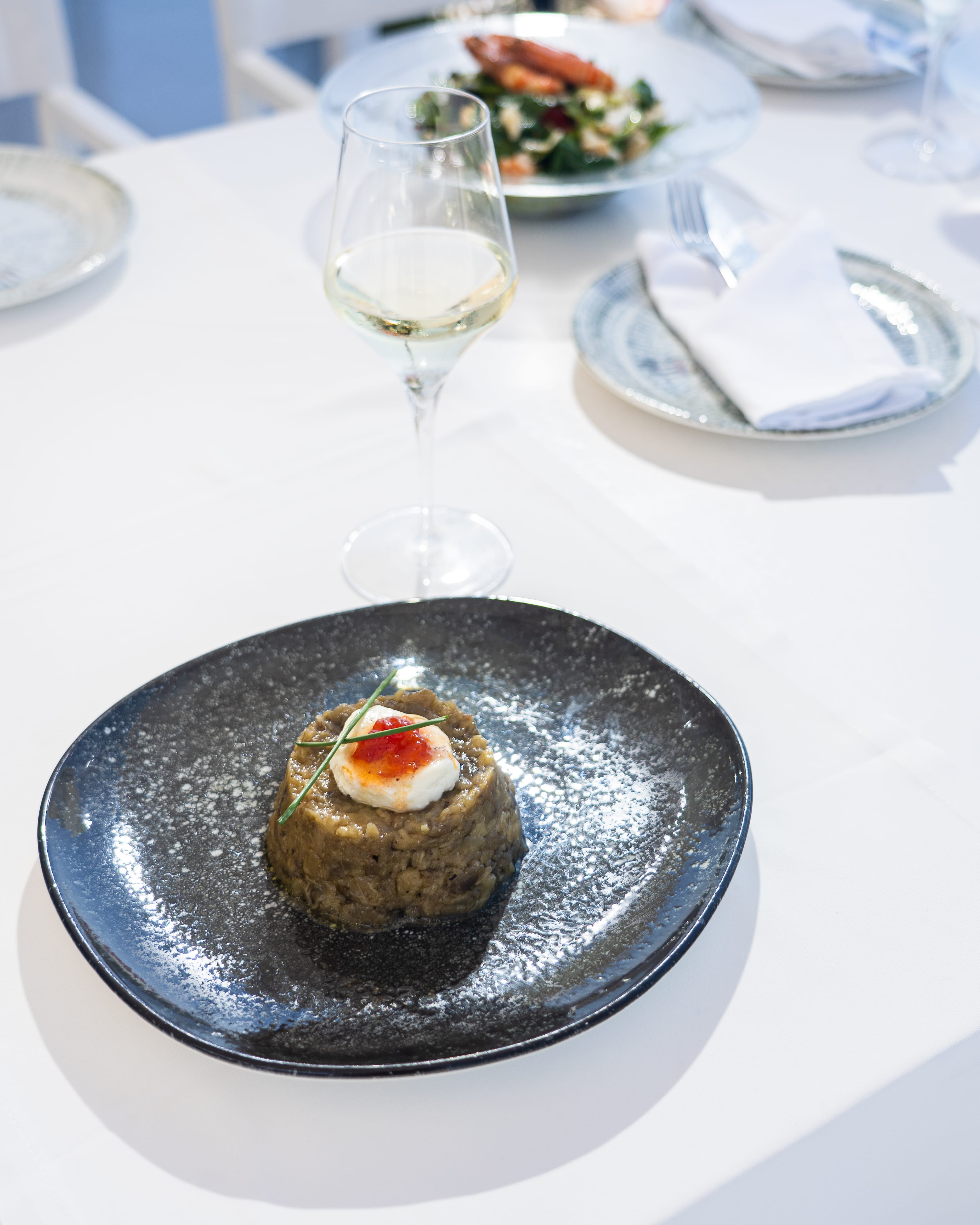 a plate of food and a glass of wine on a table