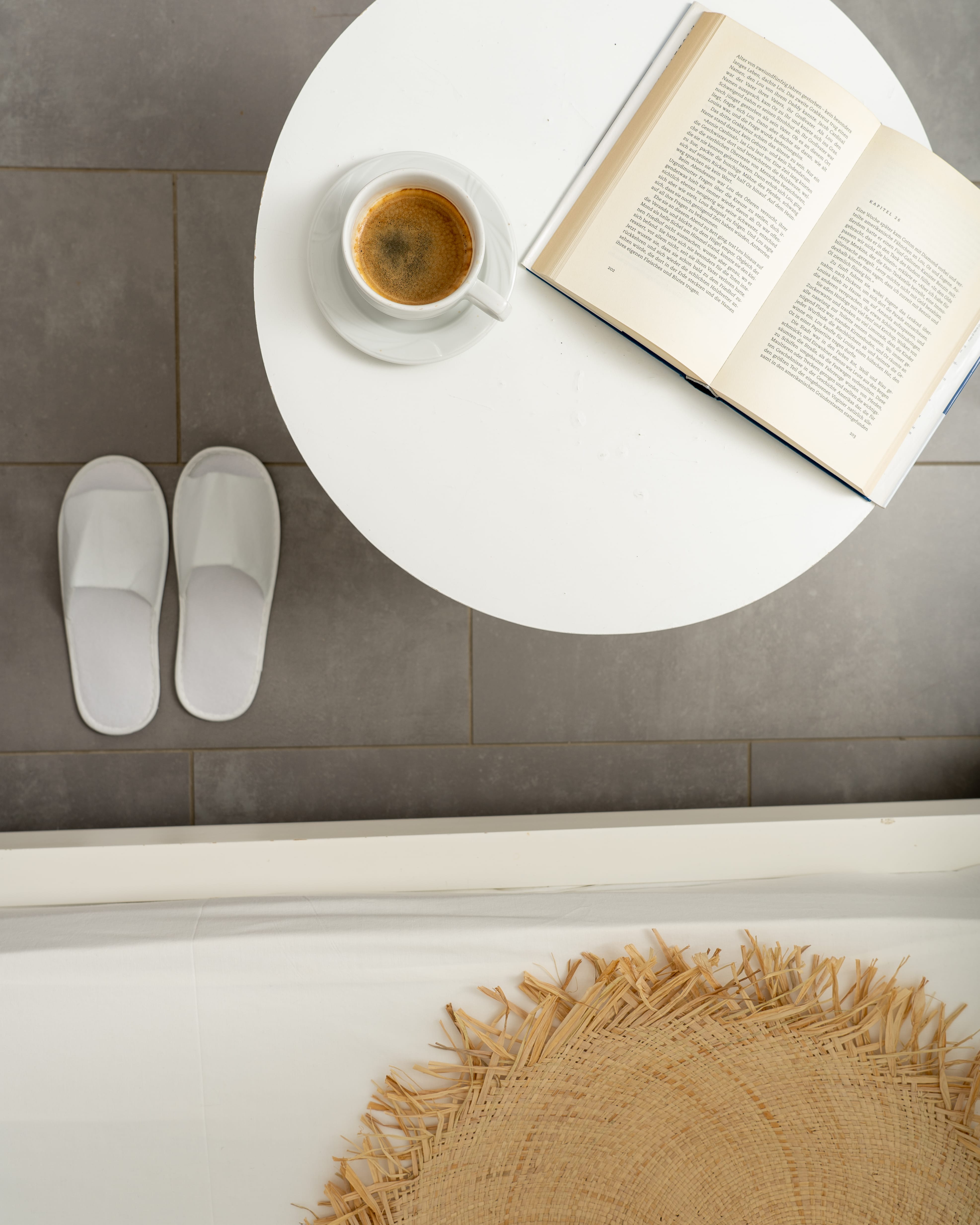 a white toilet with a magazine and a roll of toilet paper