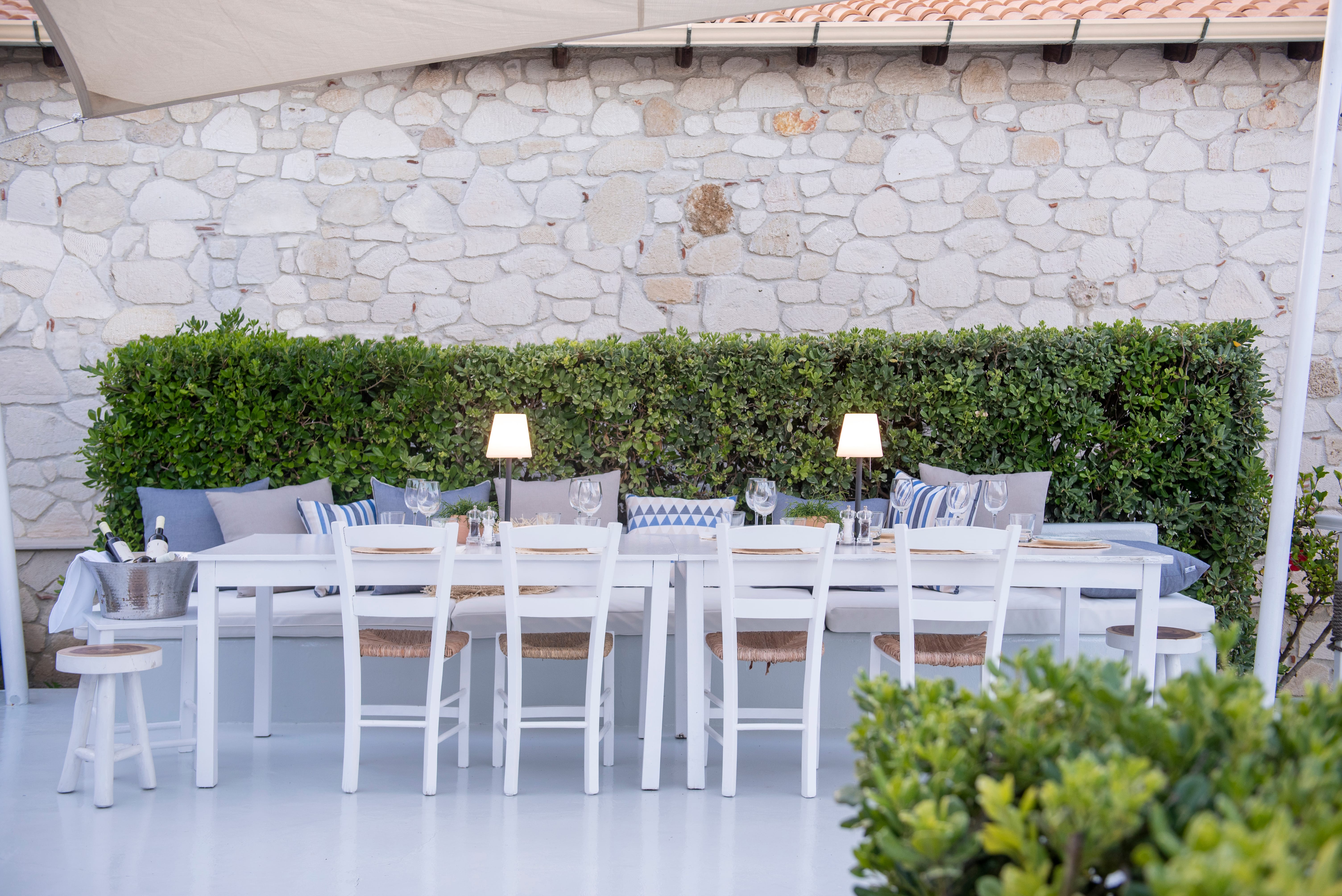 a table with chairs and a table with a plant in the background