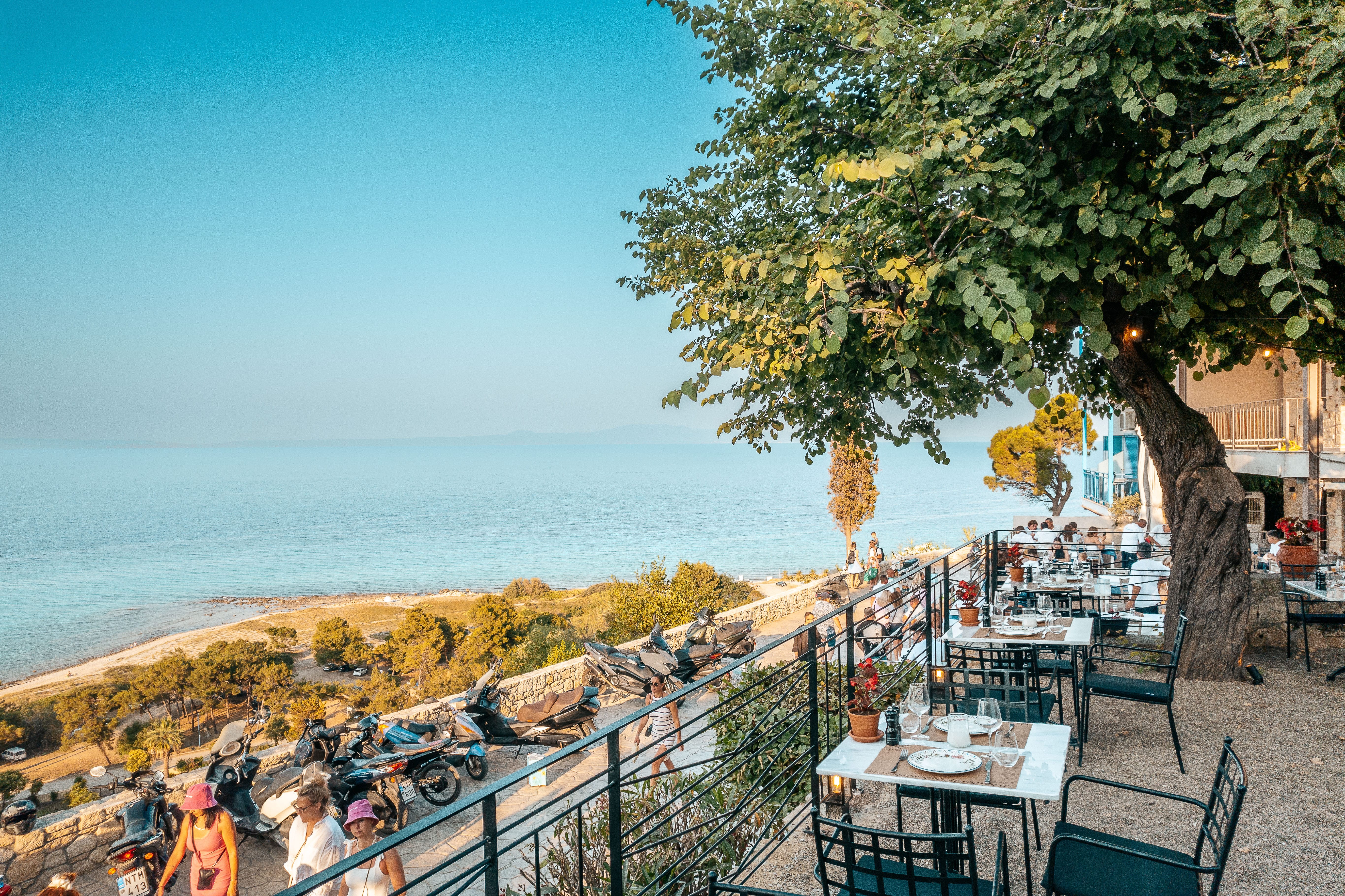 a group of people sitting at tables on a beach