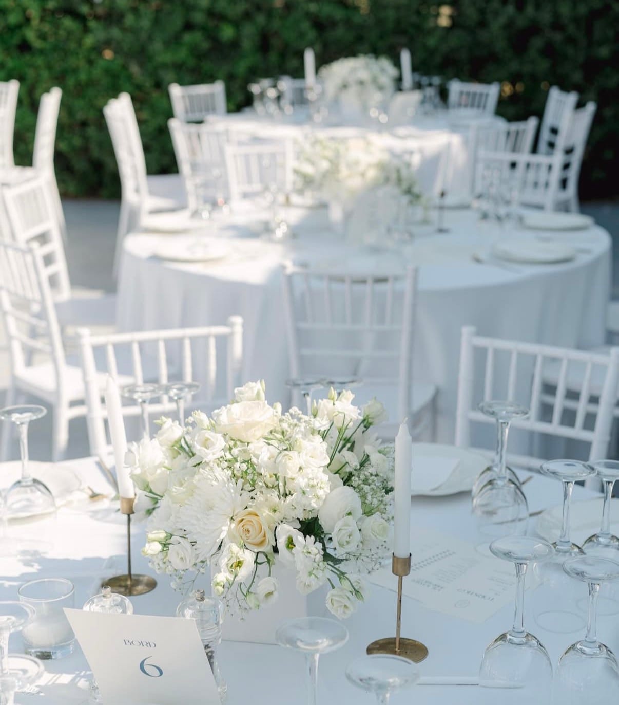 a set of tables with white chairs