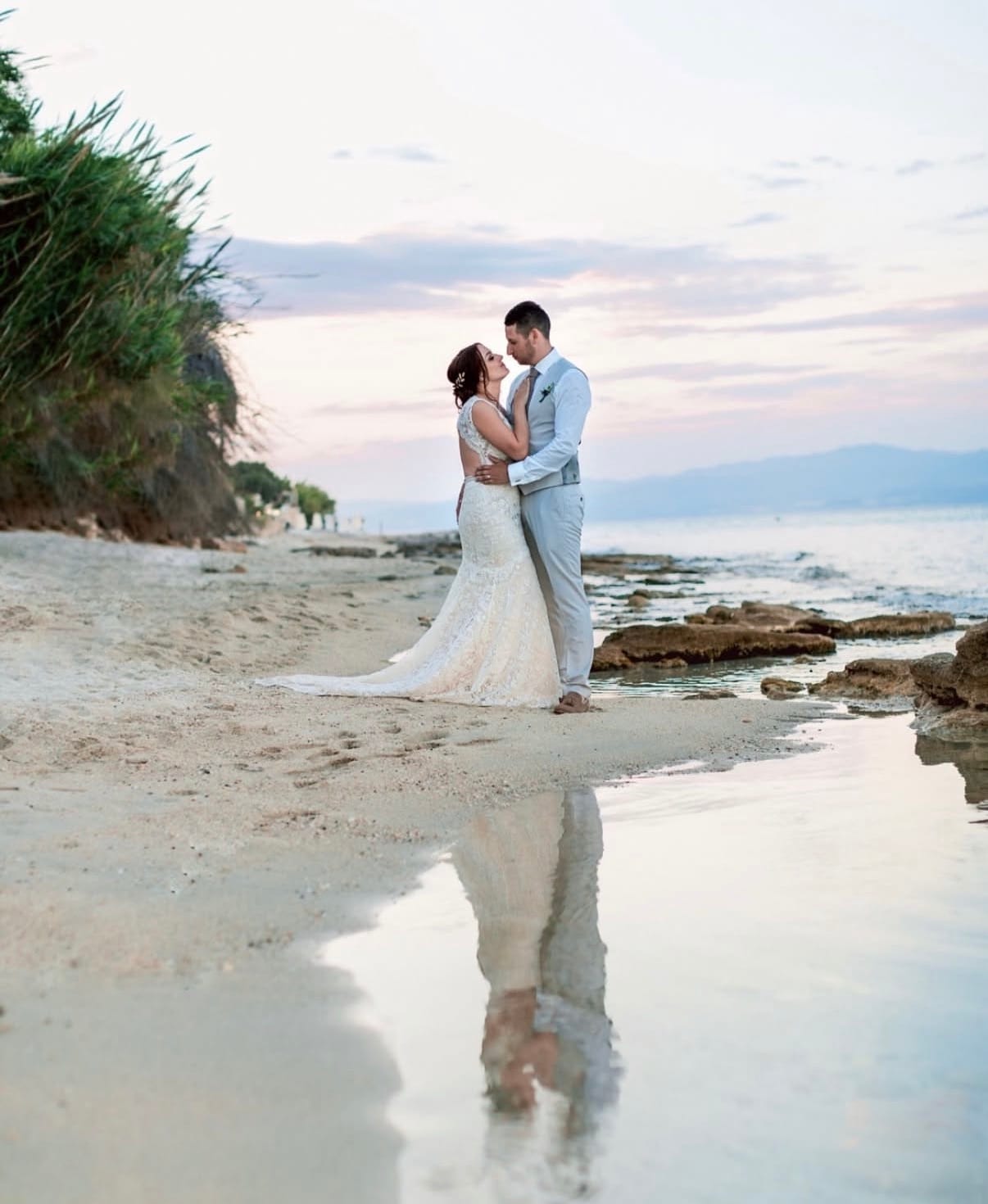 a man and woman in wedding attire on a beach