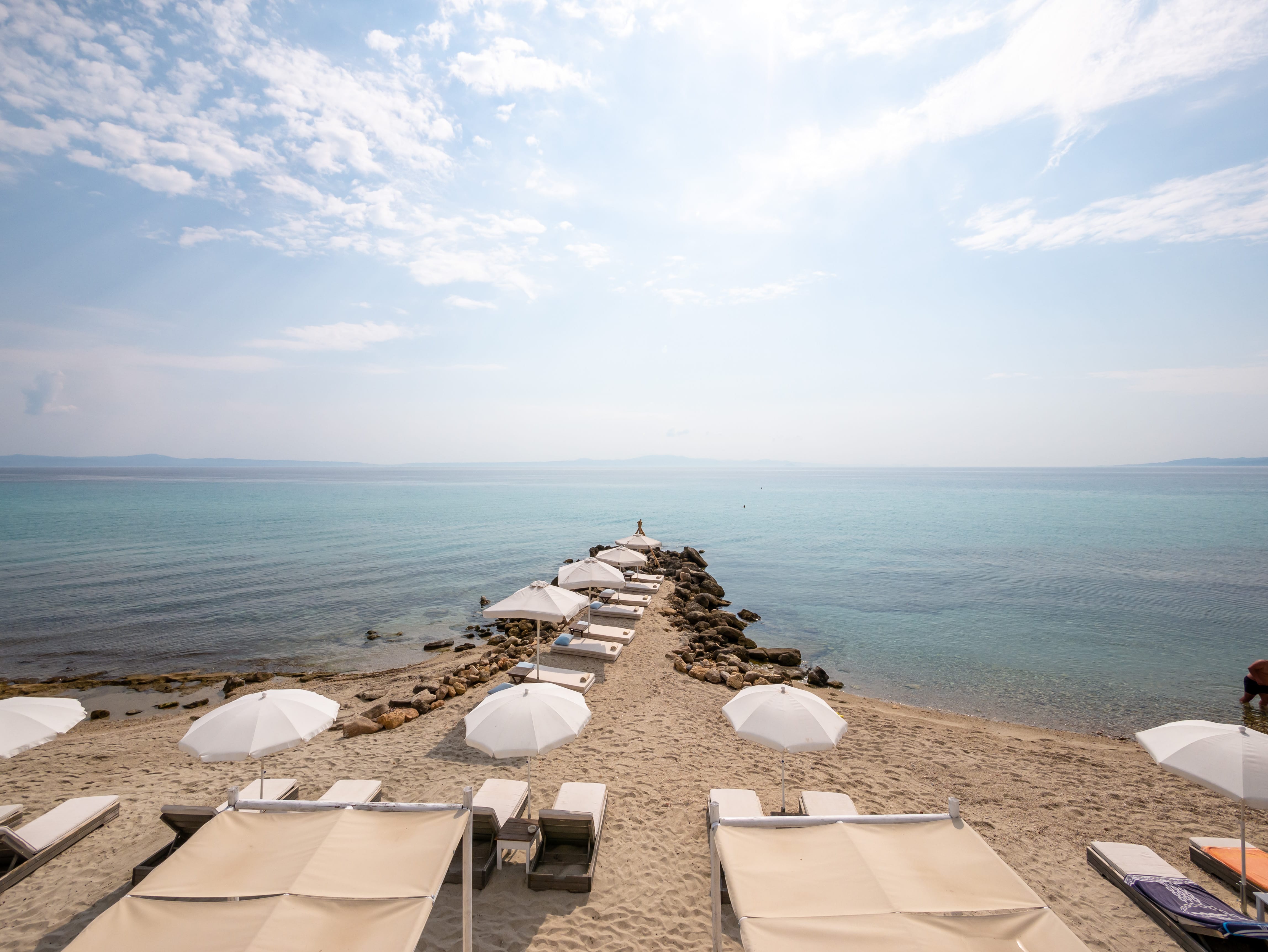 a beach with umbrellas and chairs