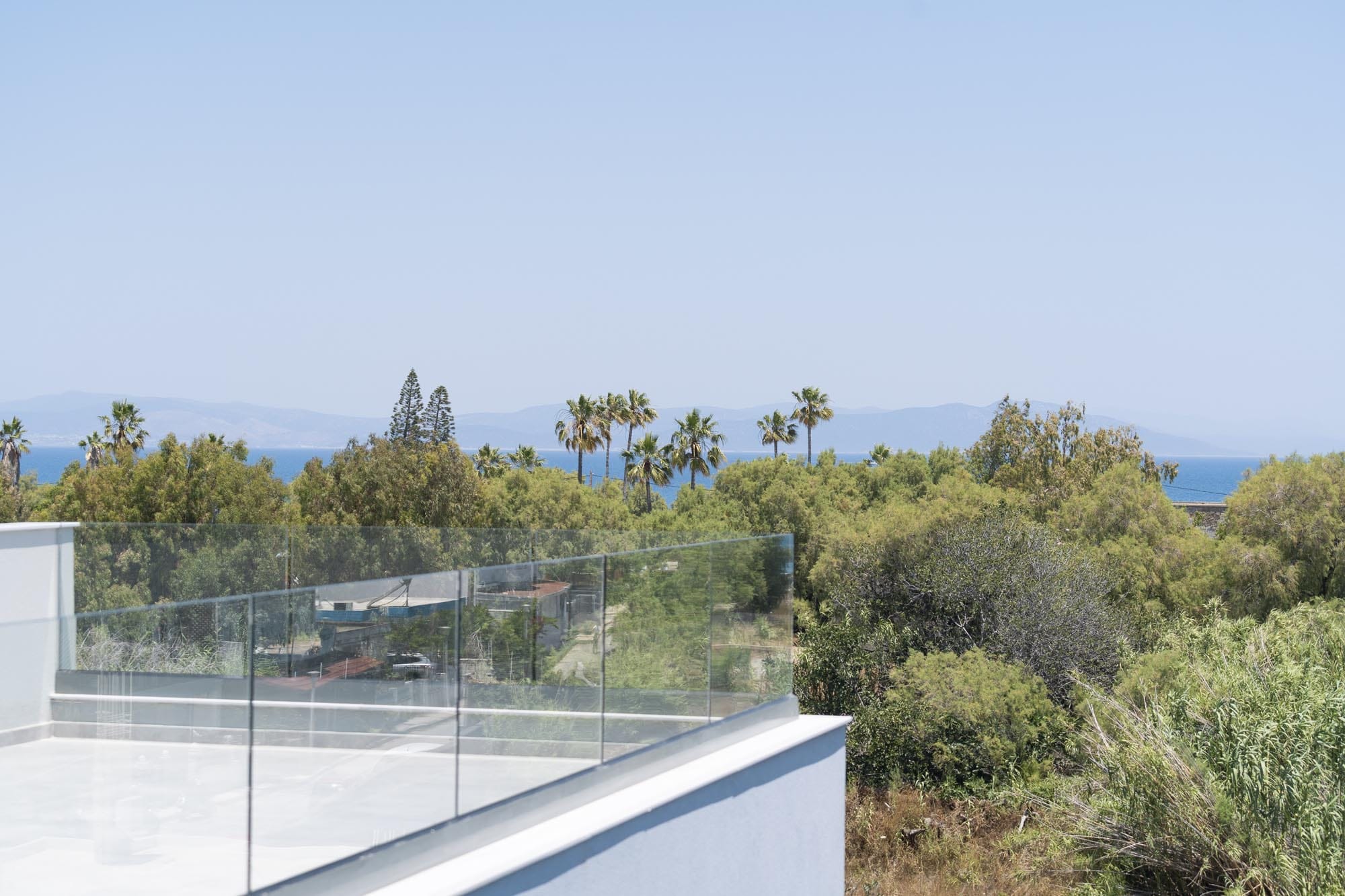 a roof with trees and a body of water in the background
