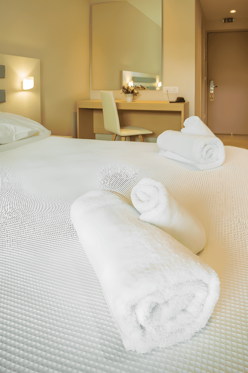 a bed with white sheets and pillows