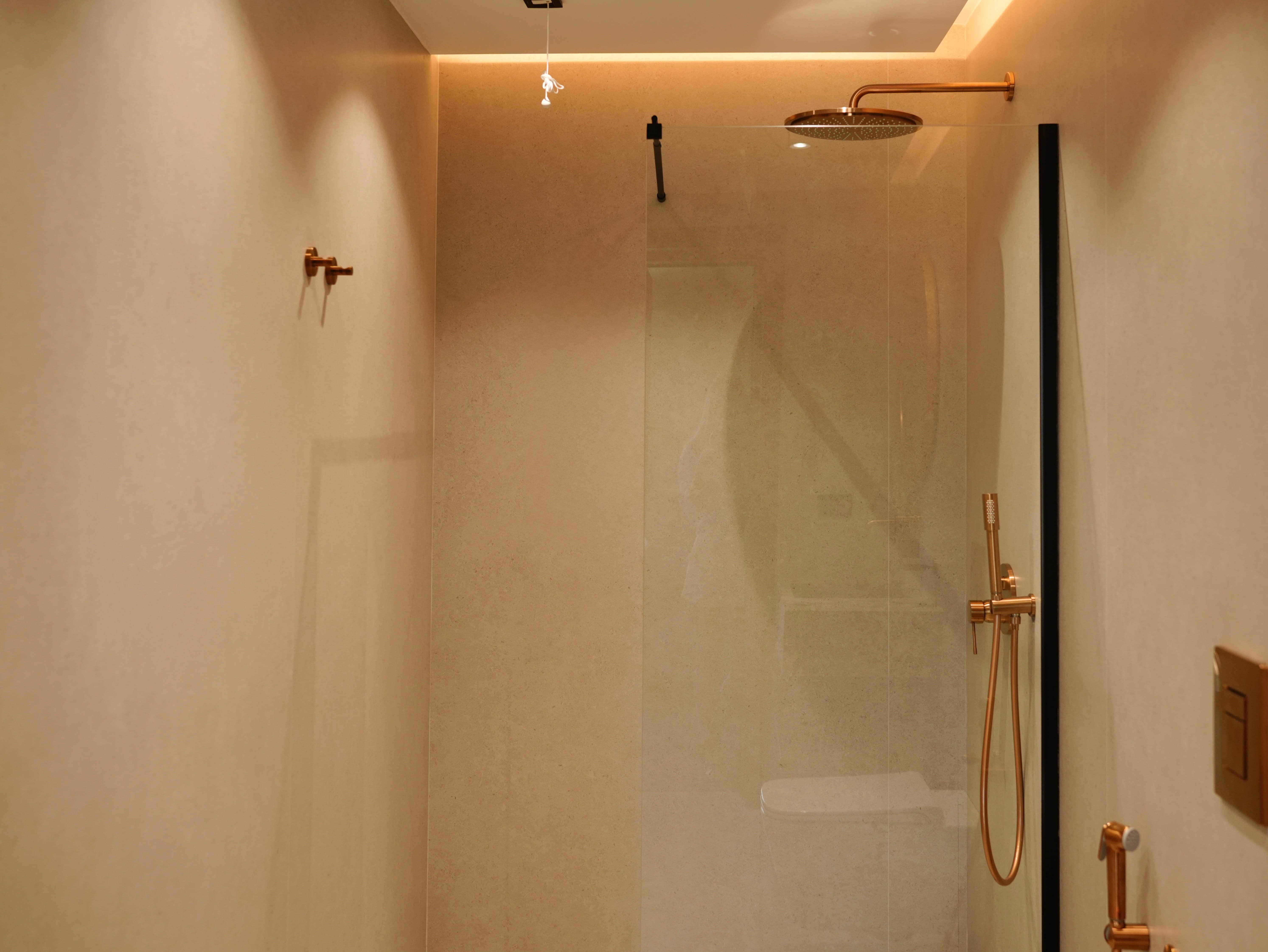 a shower with a gold shower head