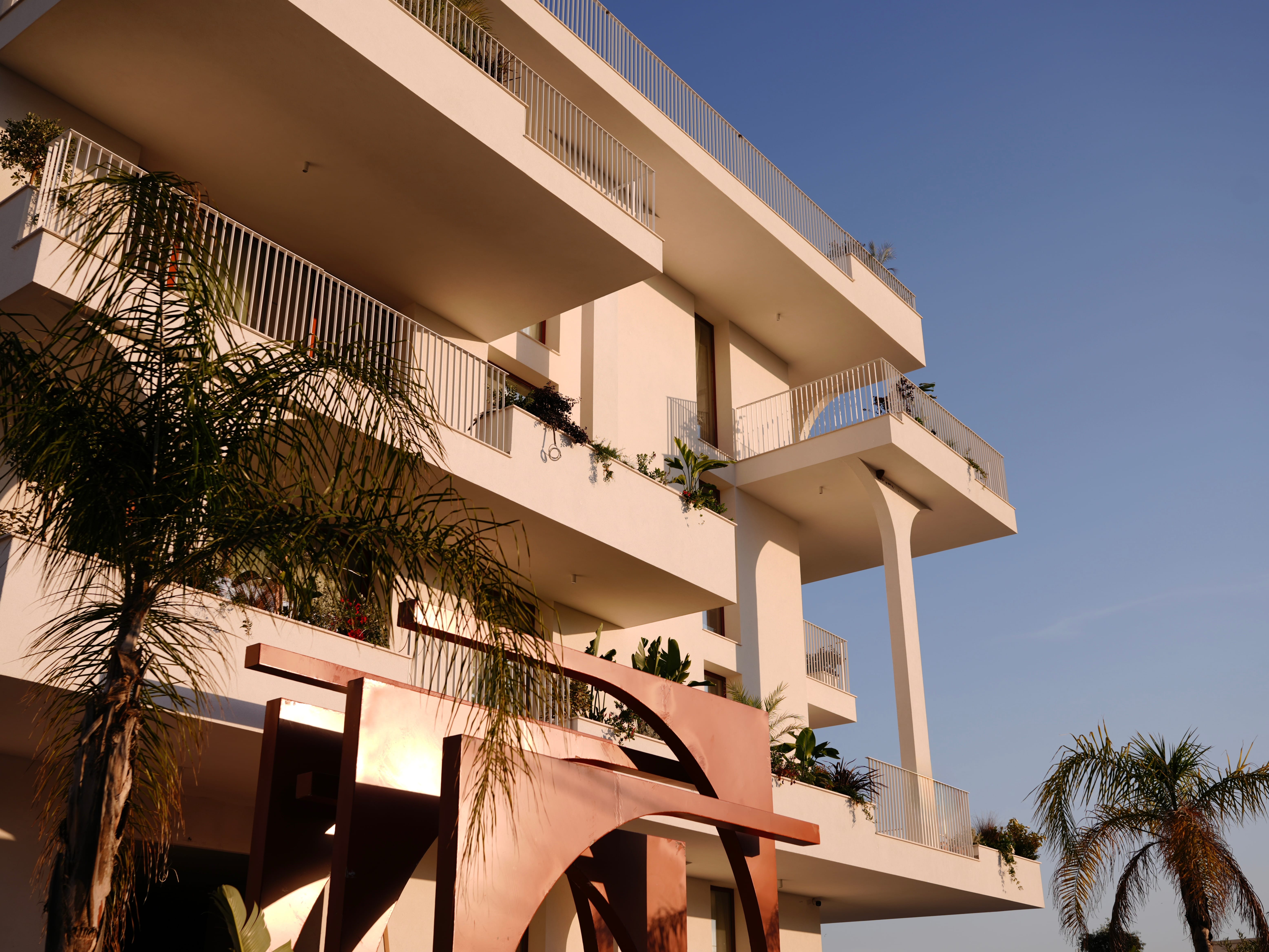 a building with balconies and palm trees