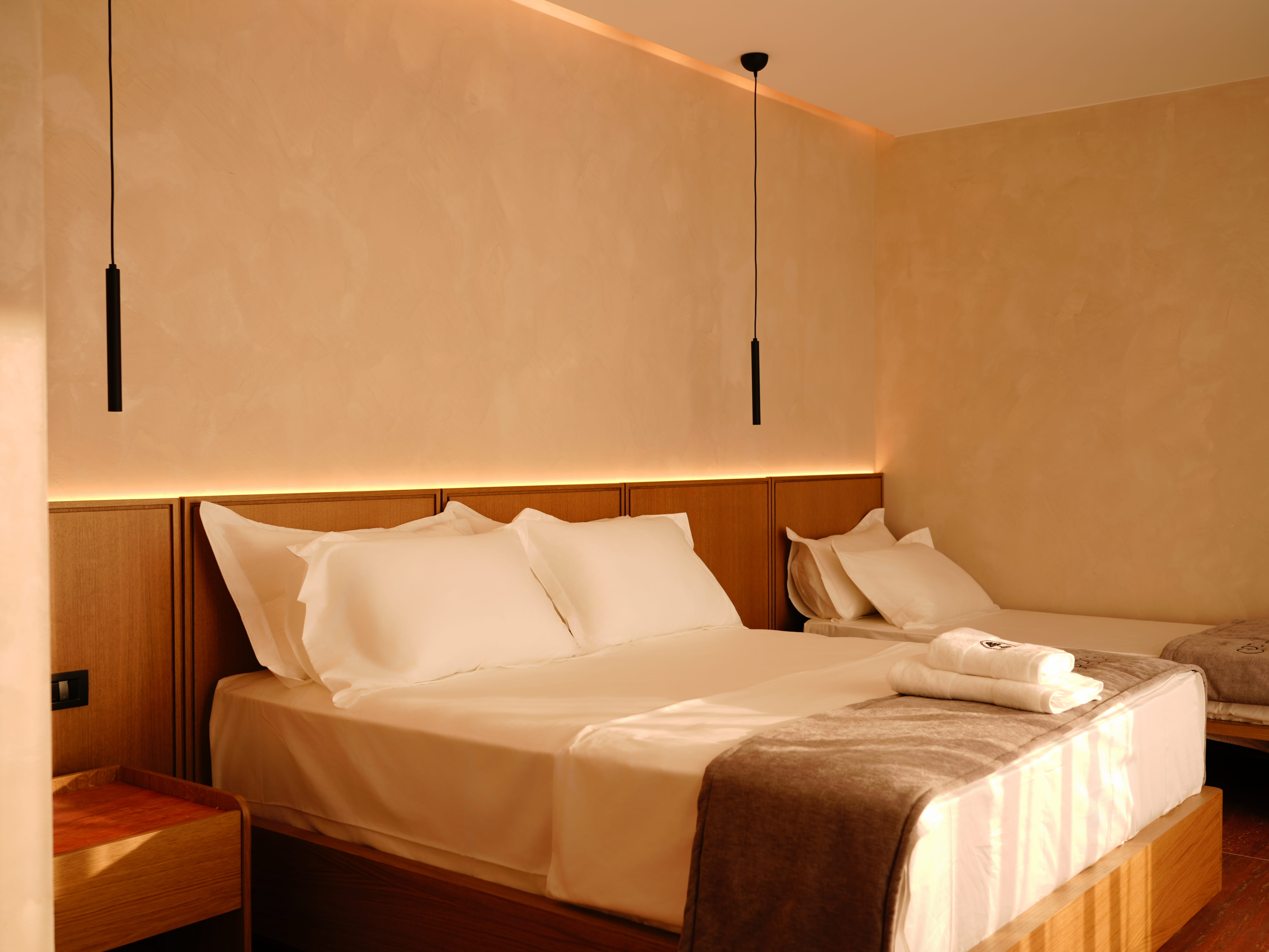 a bed with white sheets and a brown blanket
