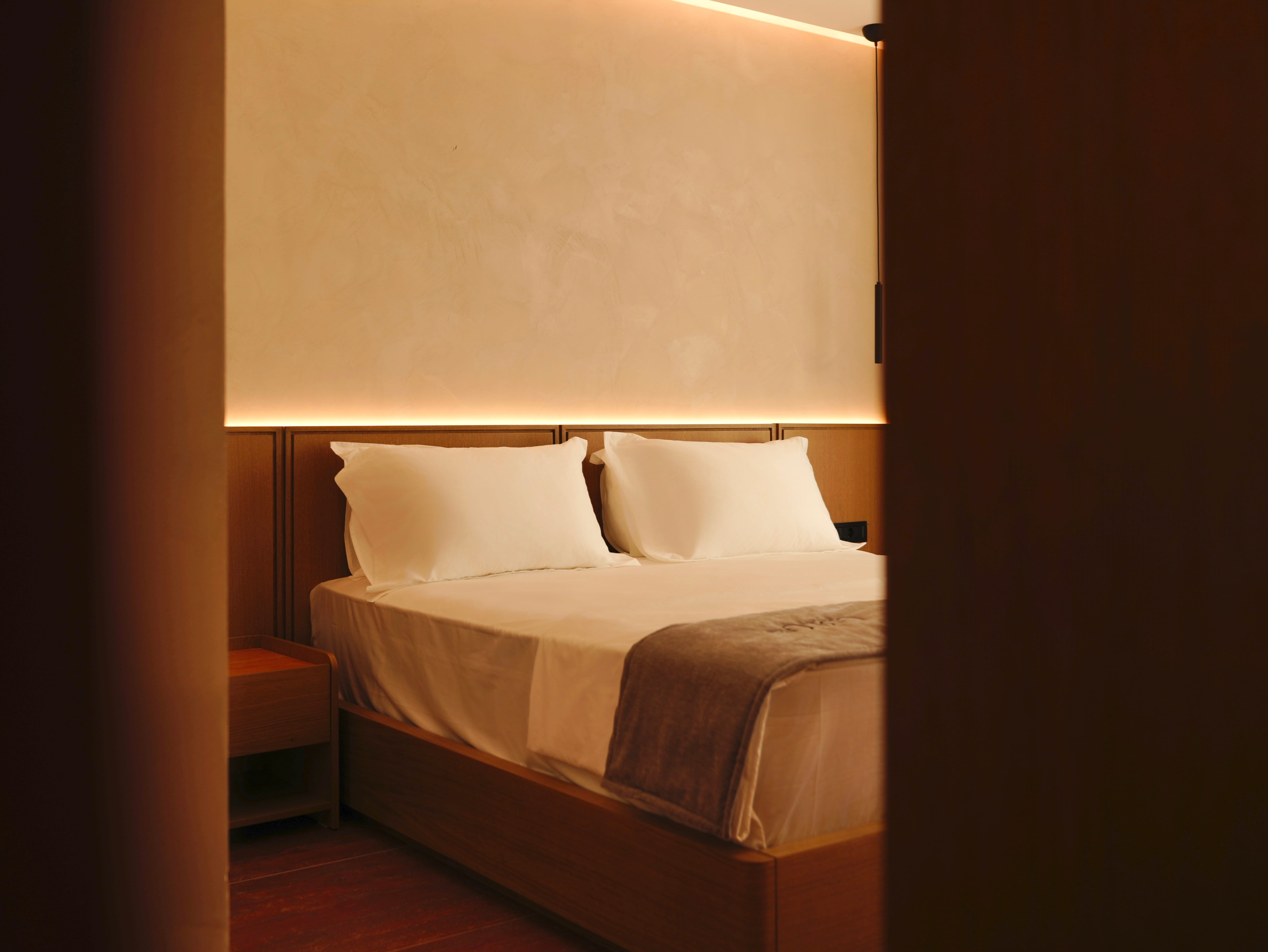 a bed with white sheets and pillows